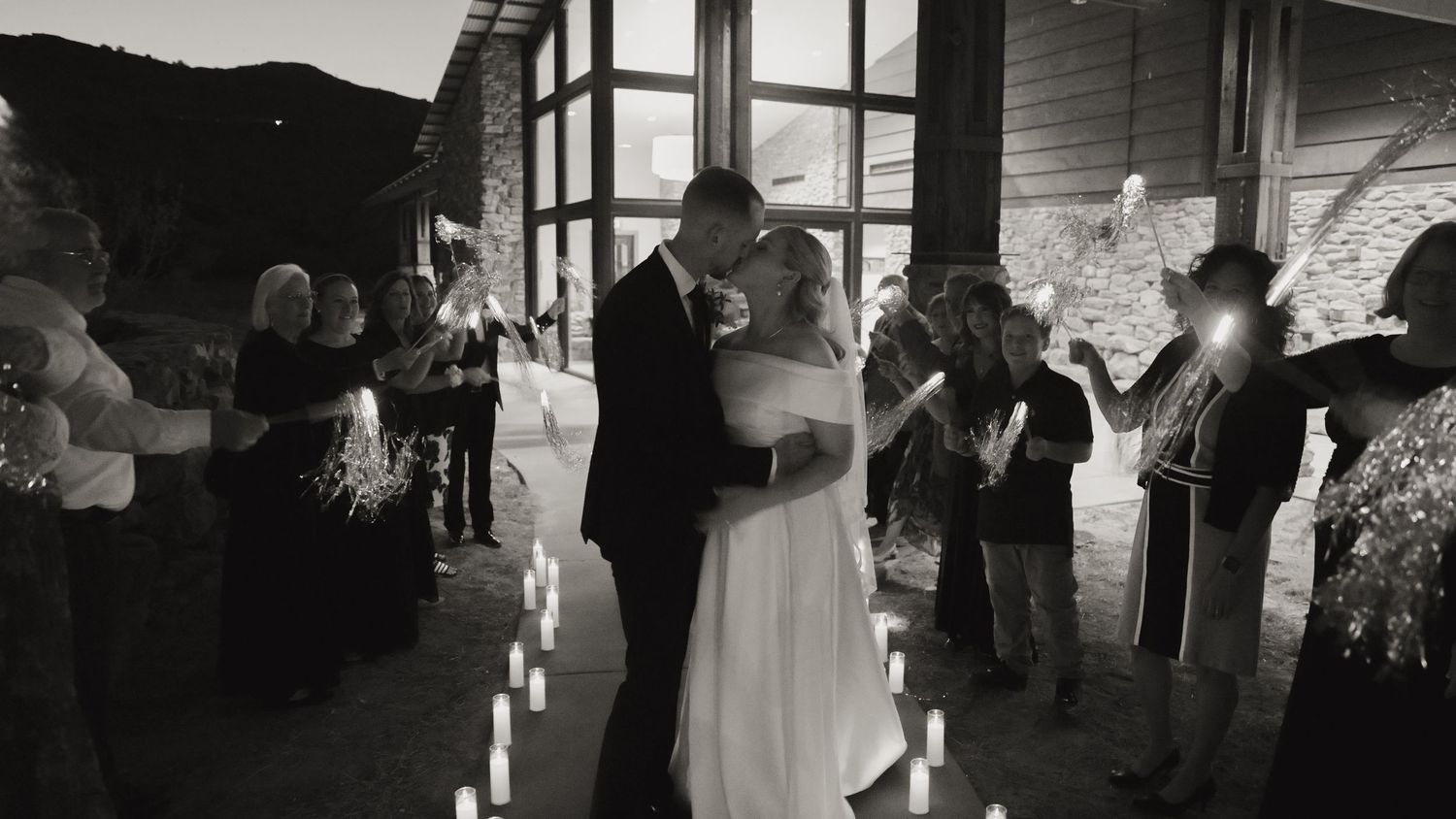 Black and white panoramic shot of a wedding reception venue with guests mingling.
