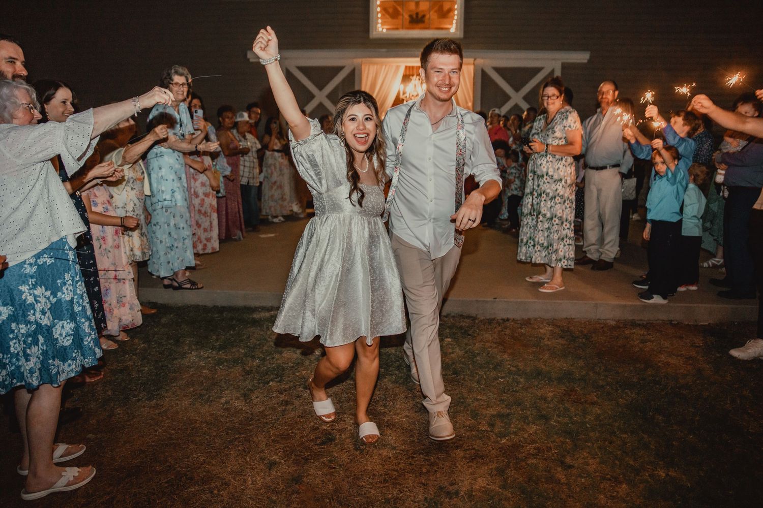 Wedding reception dance party with guests celebrating on outdoor dance floor.