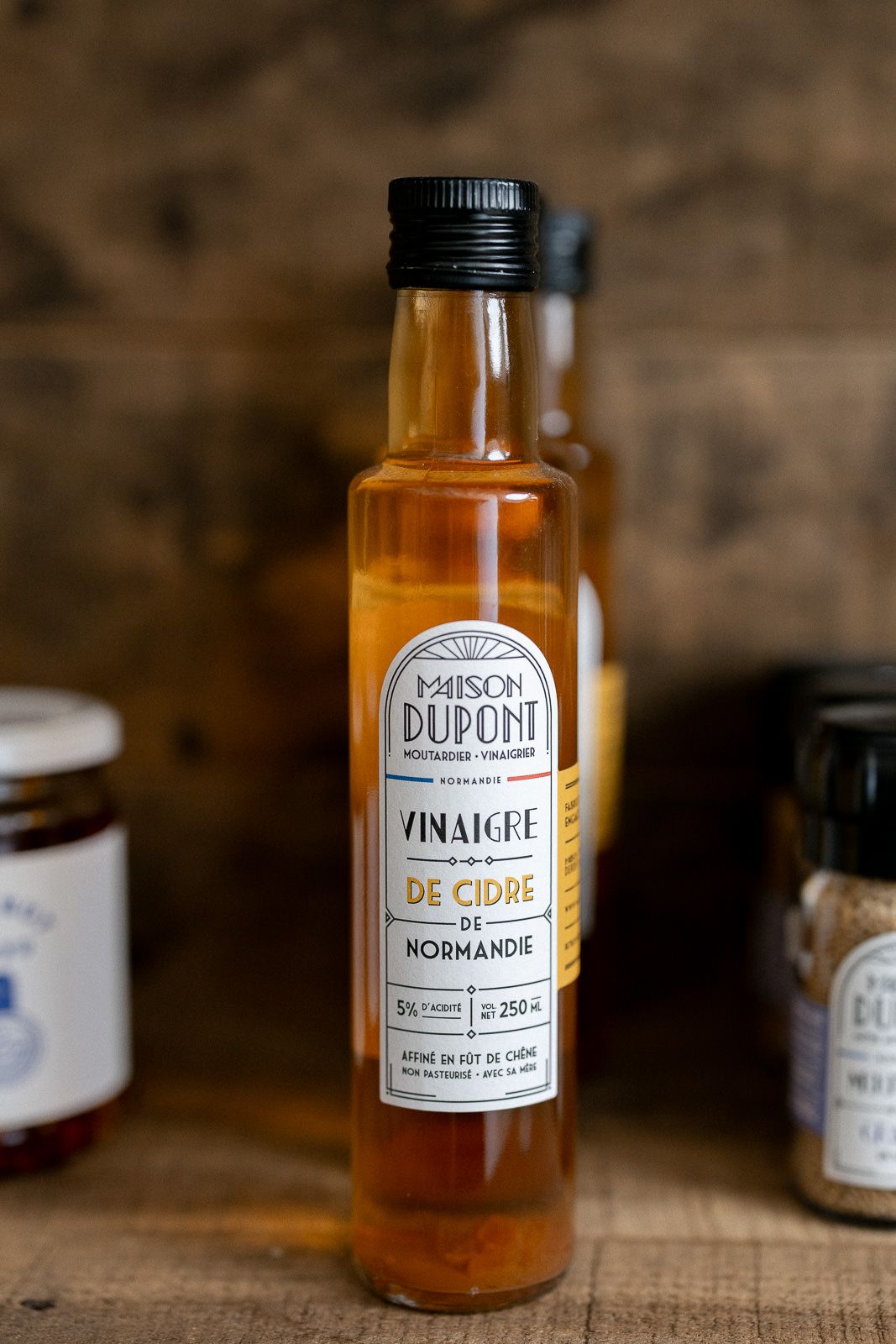 Bouteille de produit artisanal sur fond bois - photo de produit pour marque locale dans le Perche