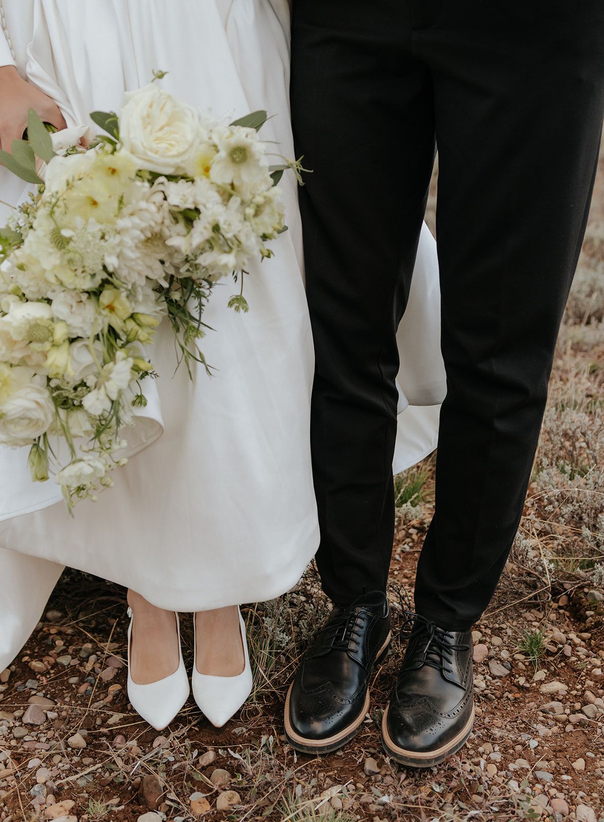Detail photo of bride and groom's wedding shoes. Bridal bouquet.