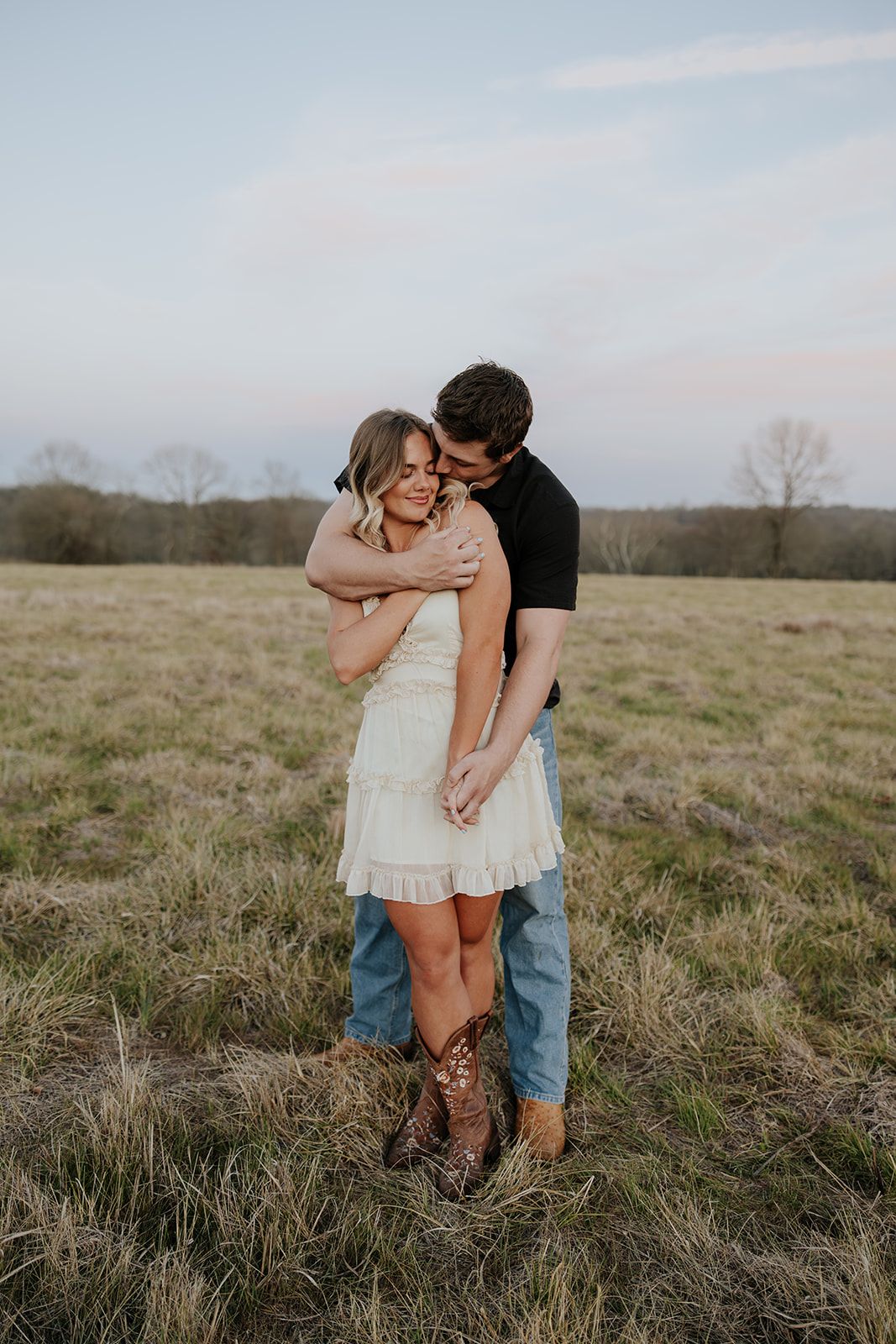 Photo of a couple in a field at sunset in Southwest Missouri