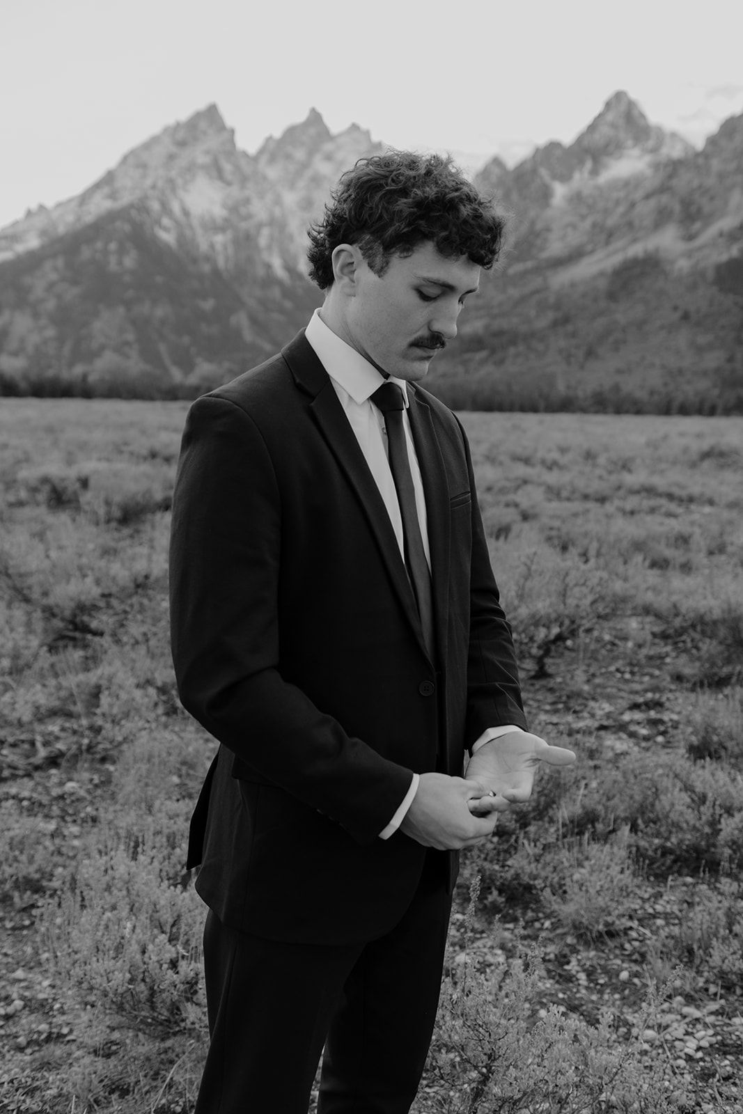 Black and white photo of groom. Groom's wedding band. Grand Teton National Park wedding
