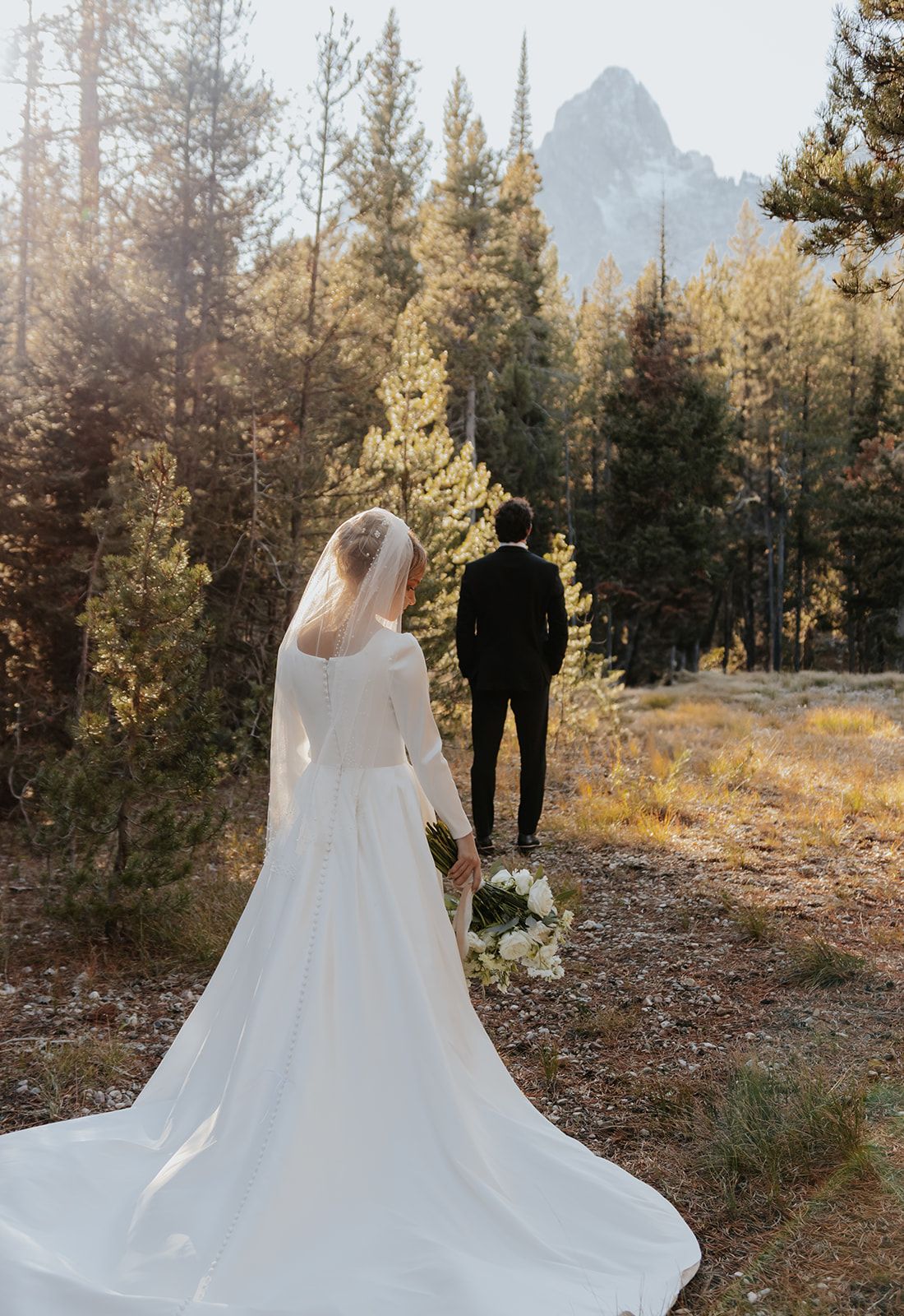 First look in Grand Teton National Park, mountain bridal photos, long wedding dress train, long bridal veil, long sleeve wedding dress