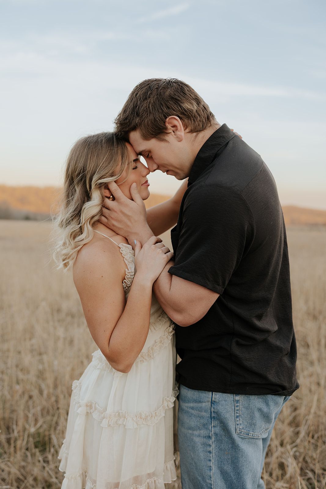 Engagement photos in a field at sunset