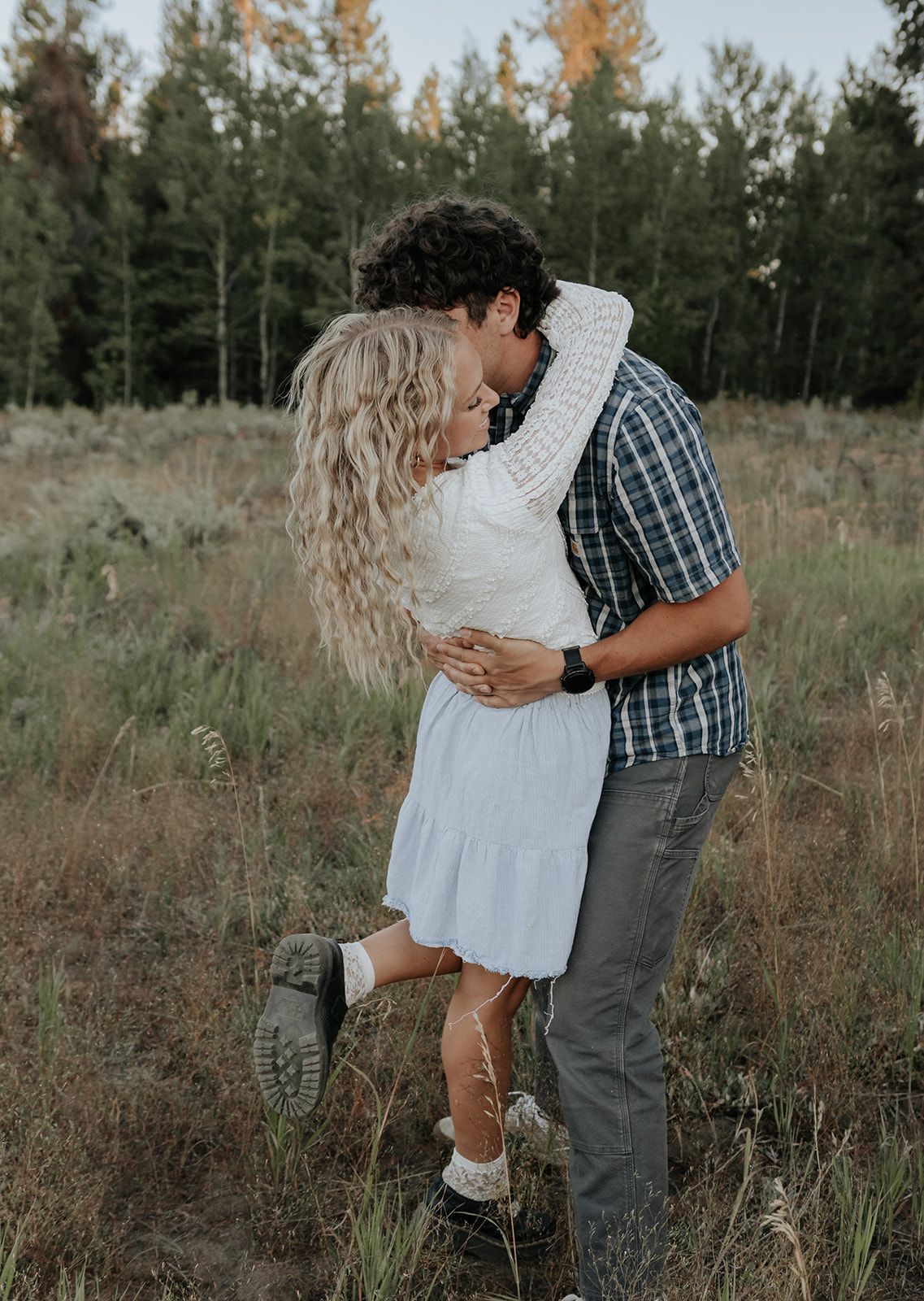 Candid couples engagement photos in Island Park, Idaho in a field during the summer