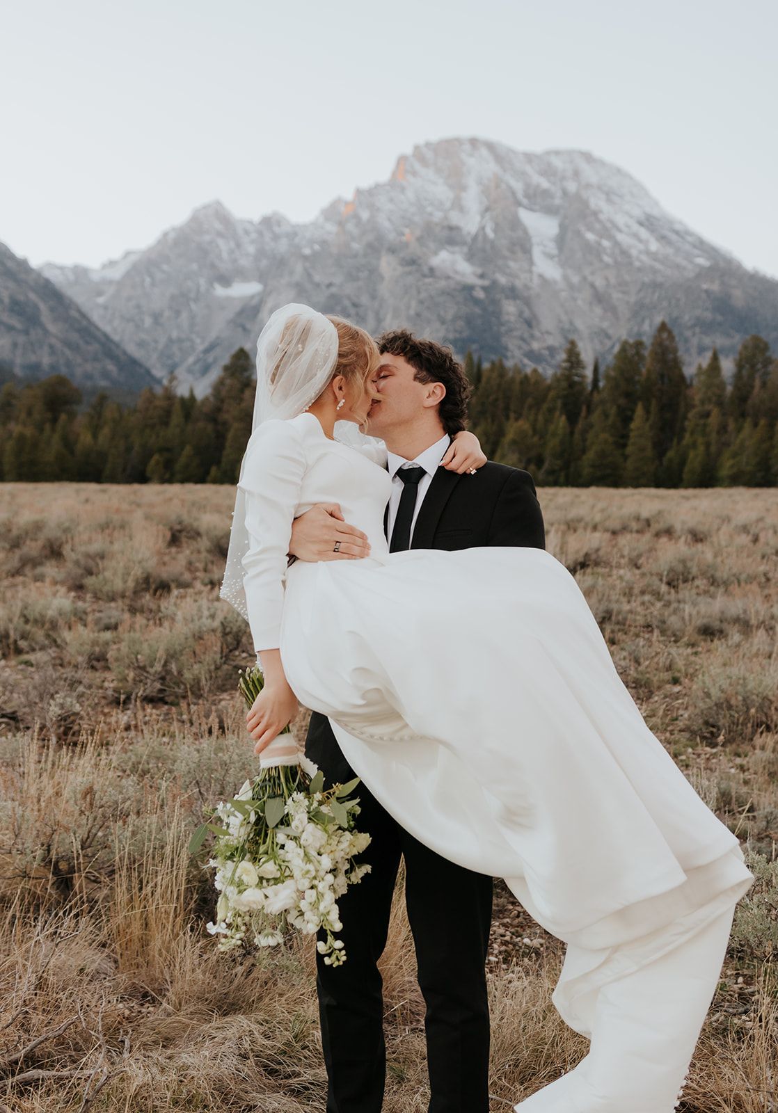 Bridal photos in Grand Teton National Park at sunset in October. Groom carrying Bride. Mount Moran.