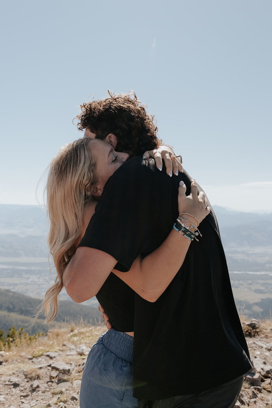 Couple hugging after getting engaged on a hike to Glory Peak at the top of the Teton Pass near Jackson, Wyoming