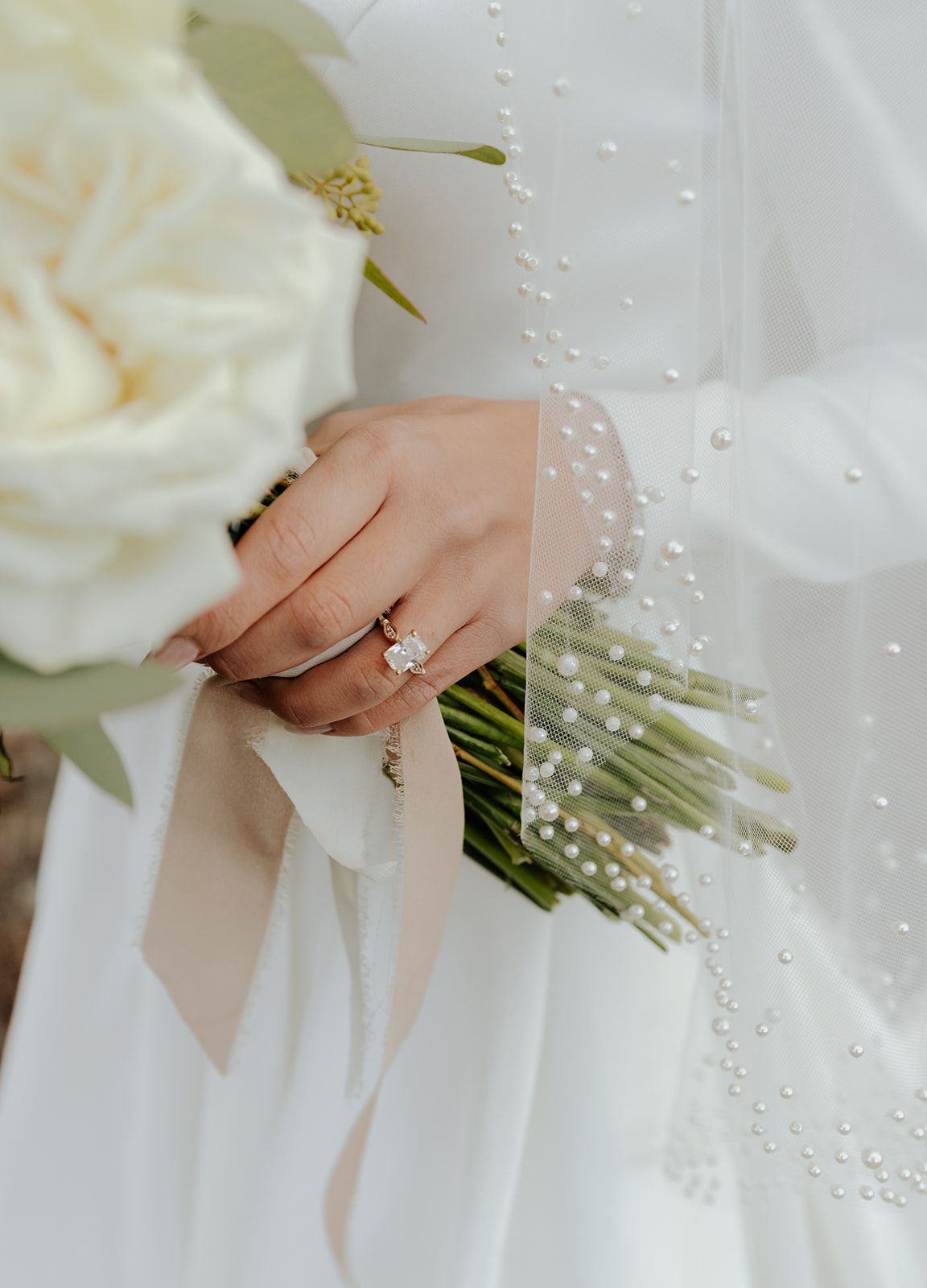 Detail photo of bride's engagement ring, veil, and bouquet. Wedding dress. Bridal veil with pearls. Margene's Bridal in Idaho Falls, Idaho