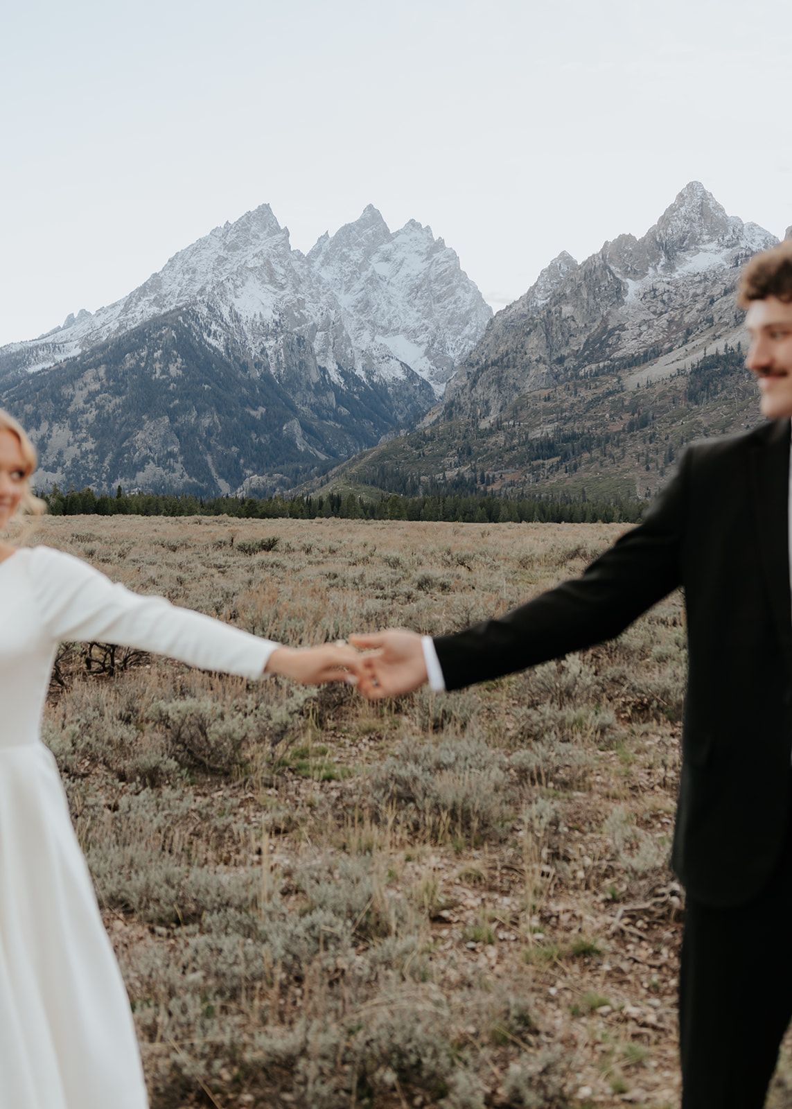 Wedding photos in Grand Teton National Park, holding hands, background in focus