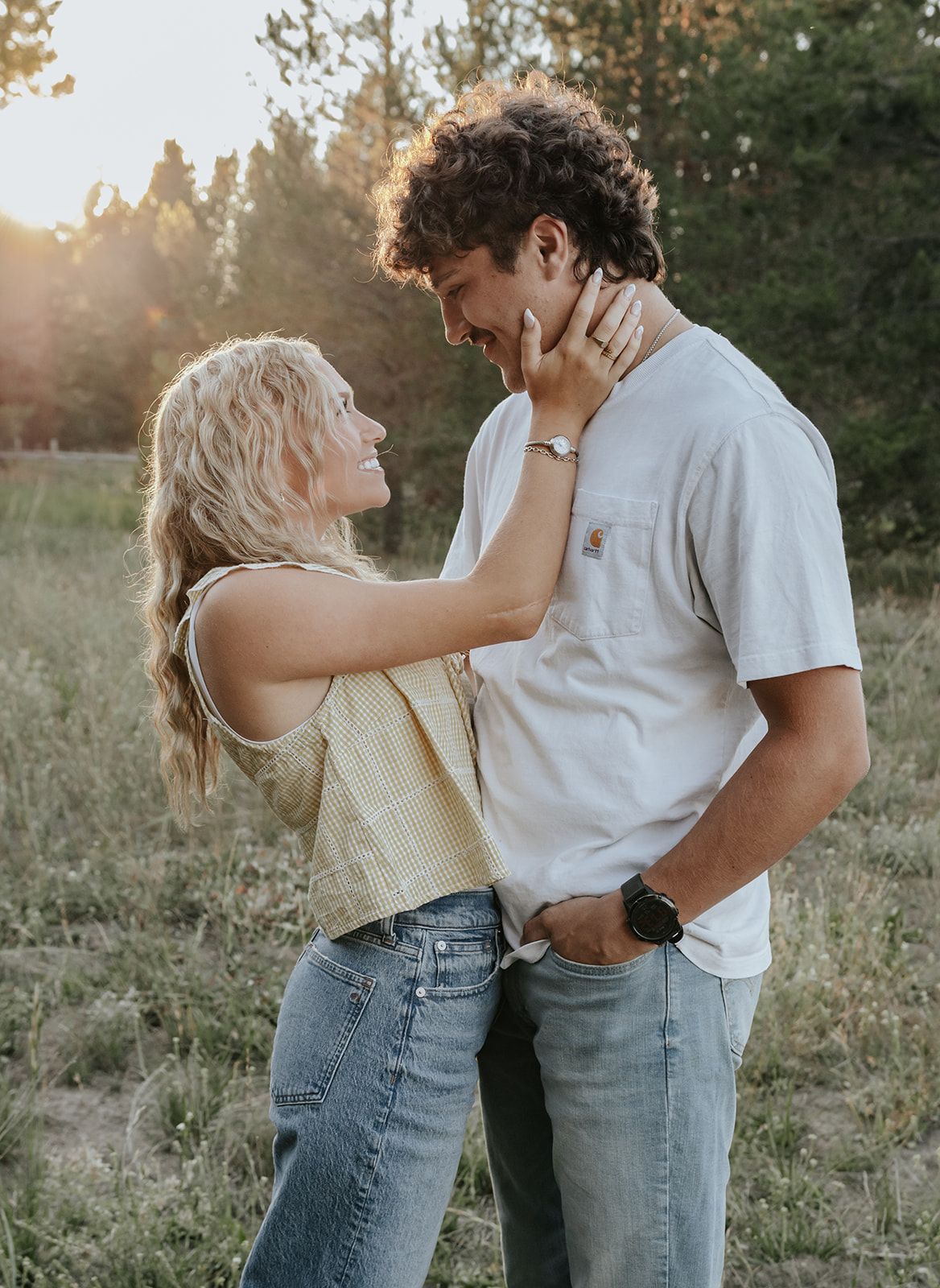 Candid couples engagement session in Island Park, Idaho in a field during the summer.