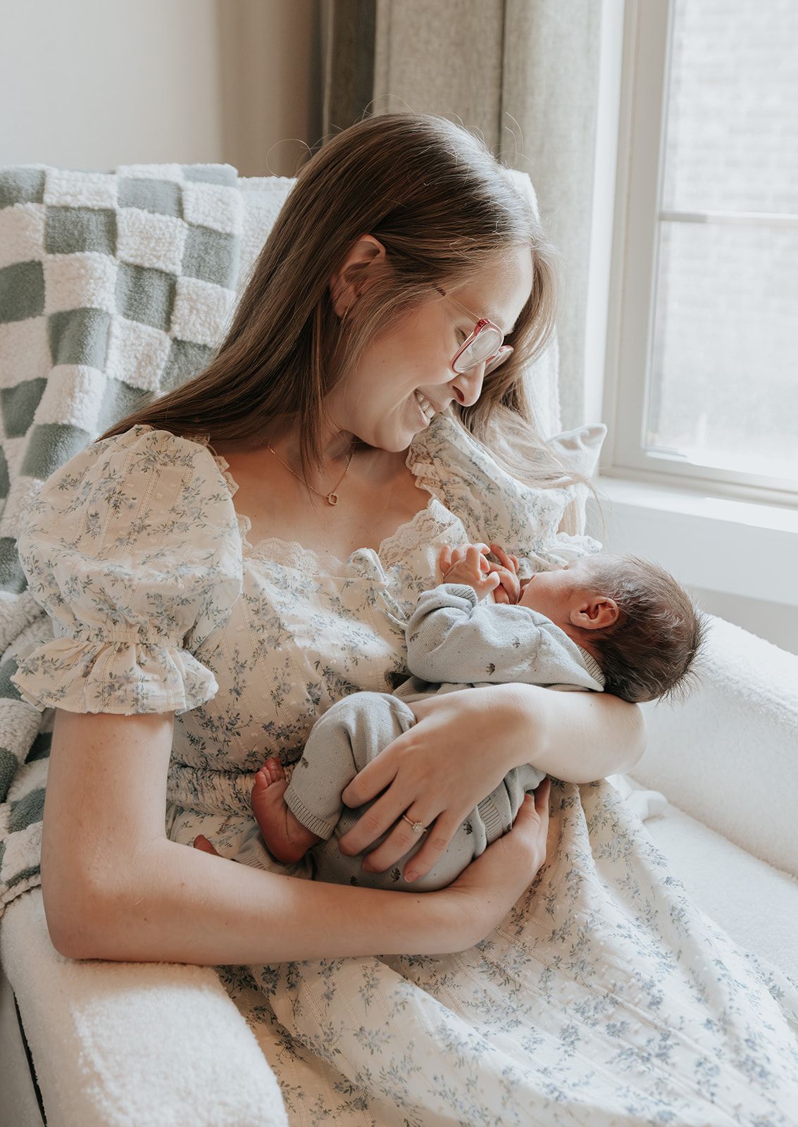 Mother and newborn baby boy in nursery during in-home newborn photoshoot in Springfield, Missouri