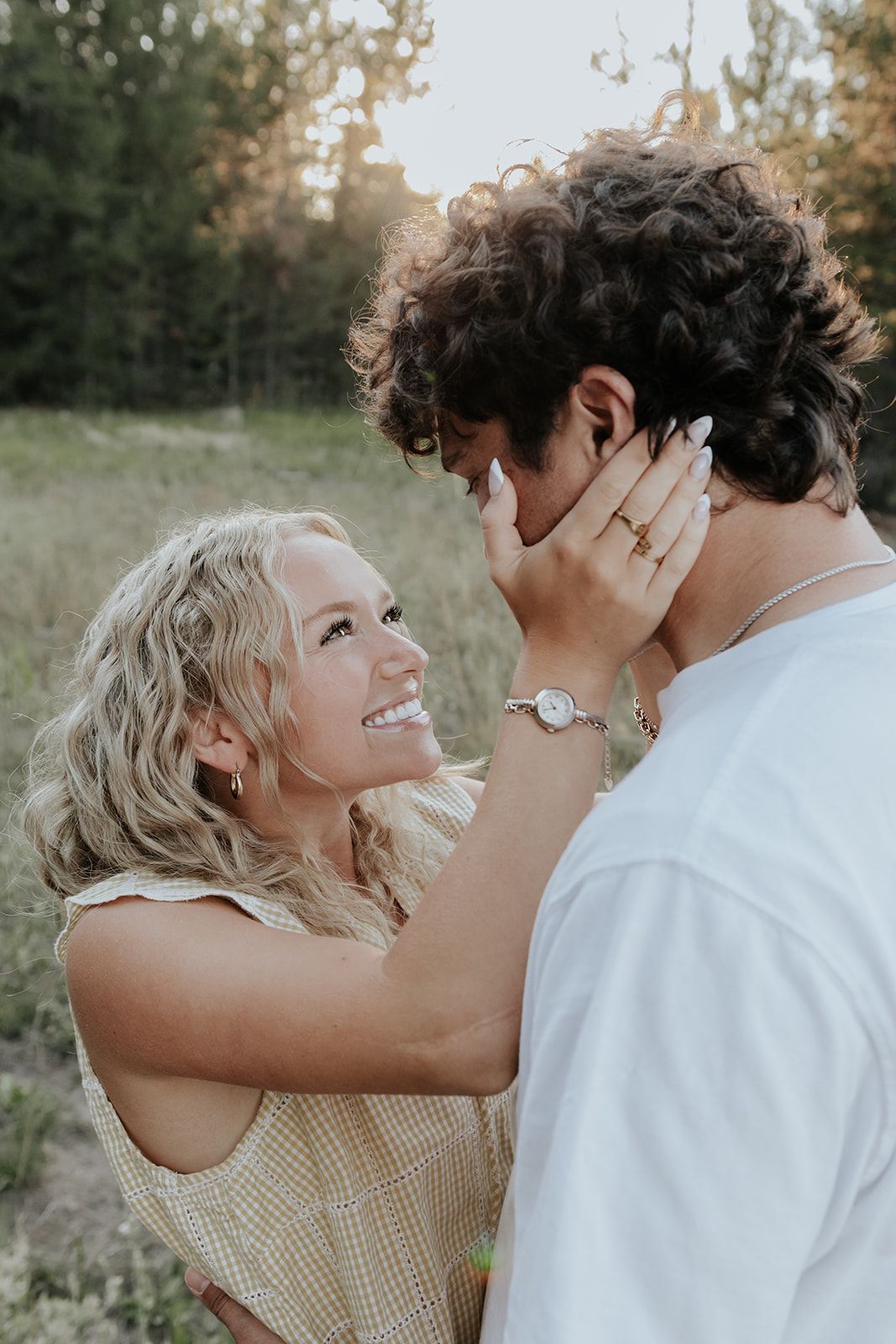 Candid couples engagement session in Island Park, Idaho in a field during the summer. Happy couples photoshoot