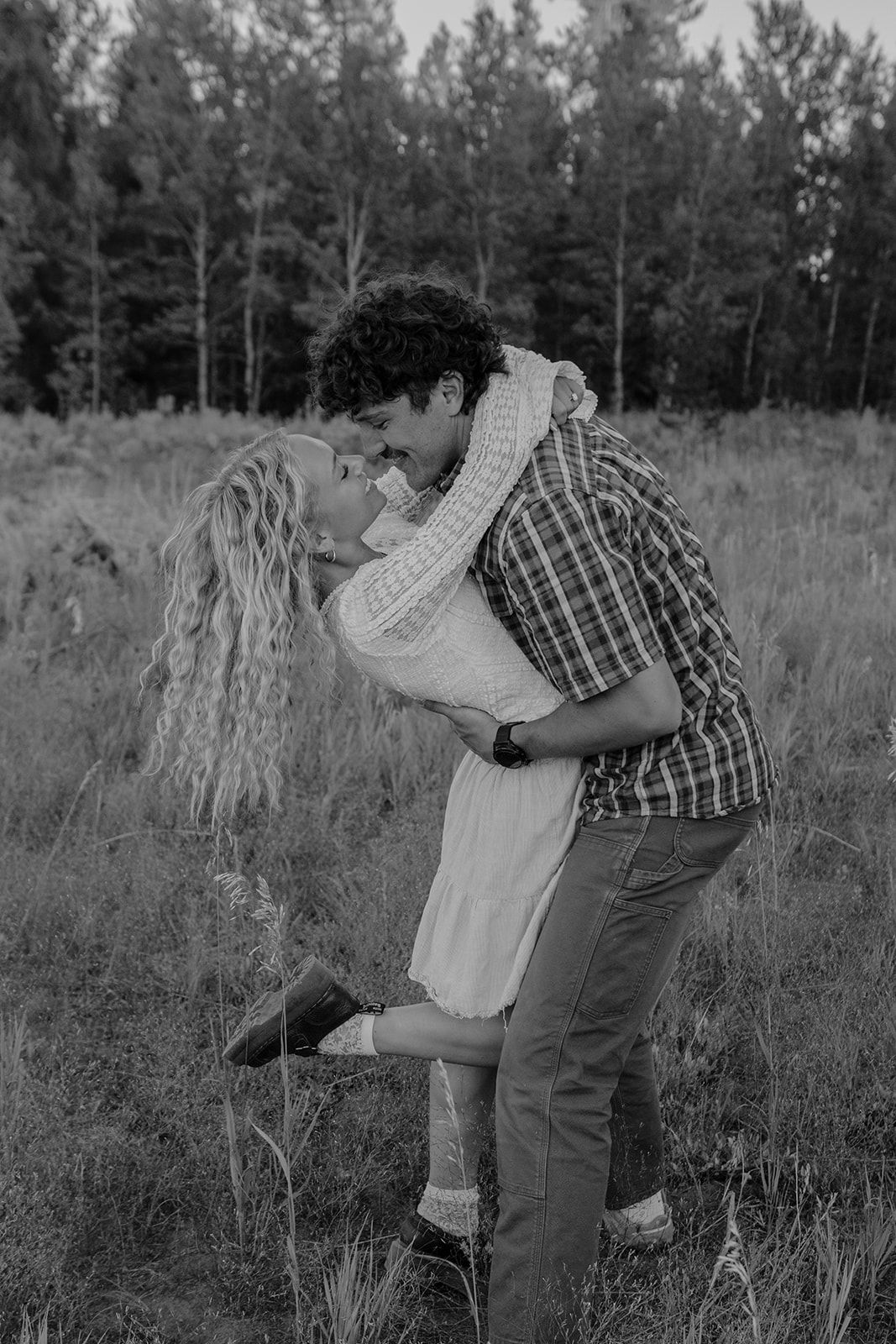 Candid couples engagement session in Island Park, Idaho in a field during the summer