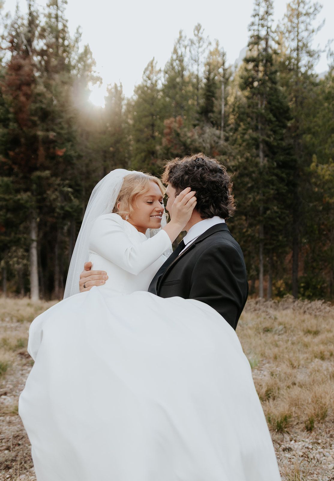 Bridal photos in the Tetons, sun flare through the pine trees