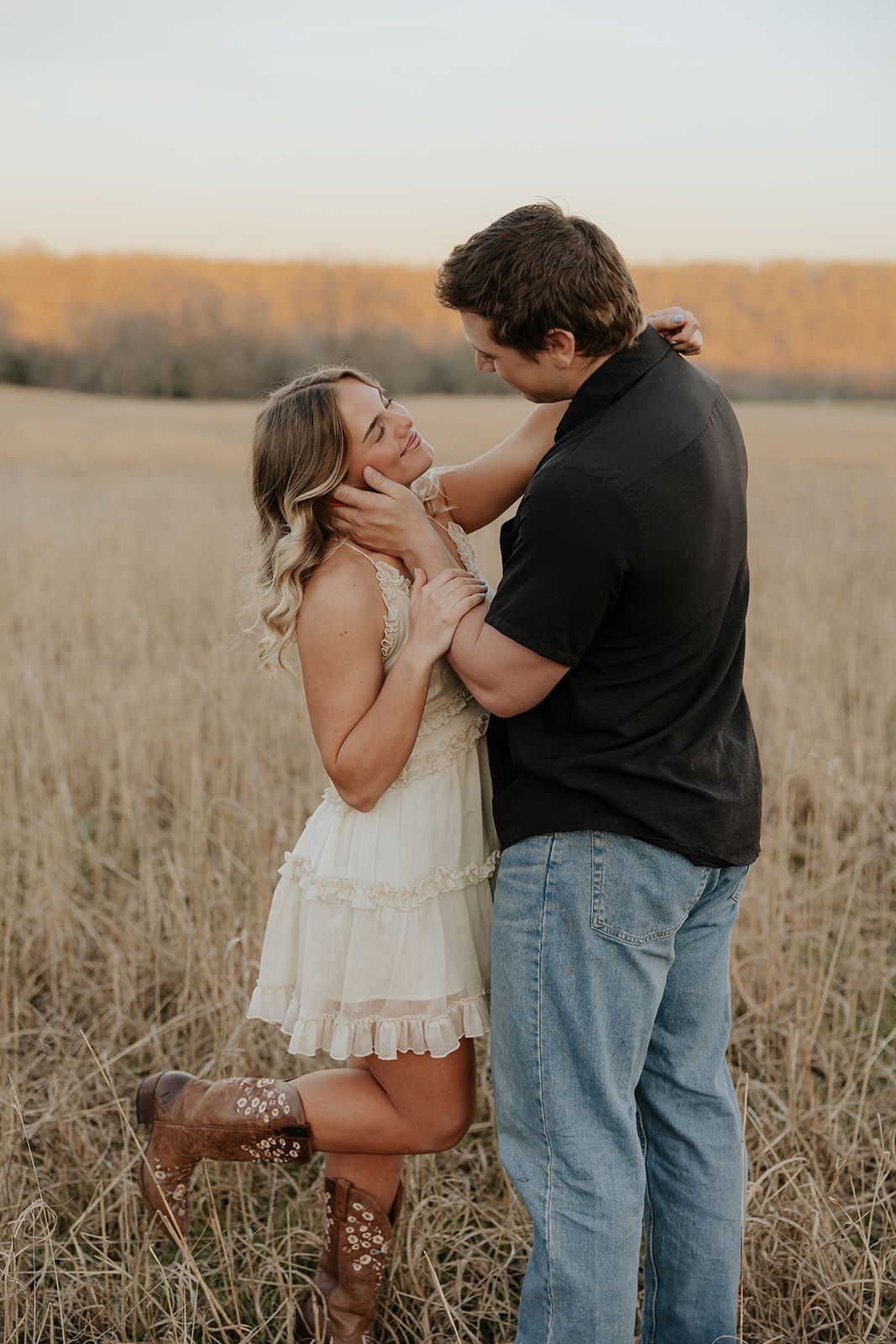 Engagement photos in a field at sunset