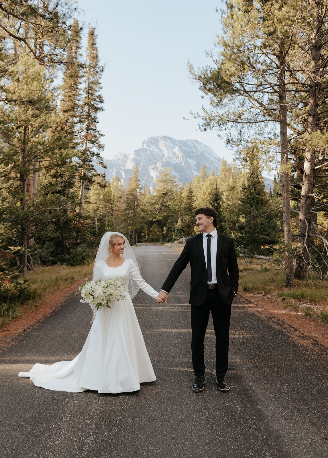Couple holding hands in Grand Teton National Park during bridal photoshoot
