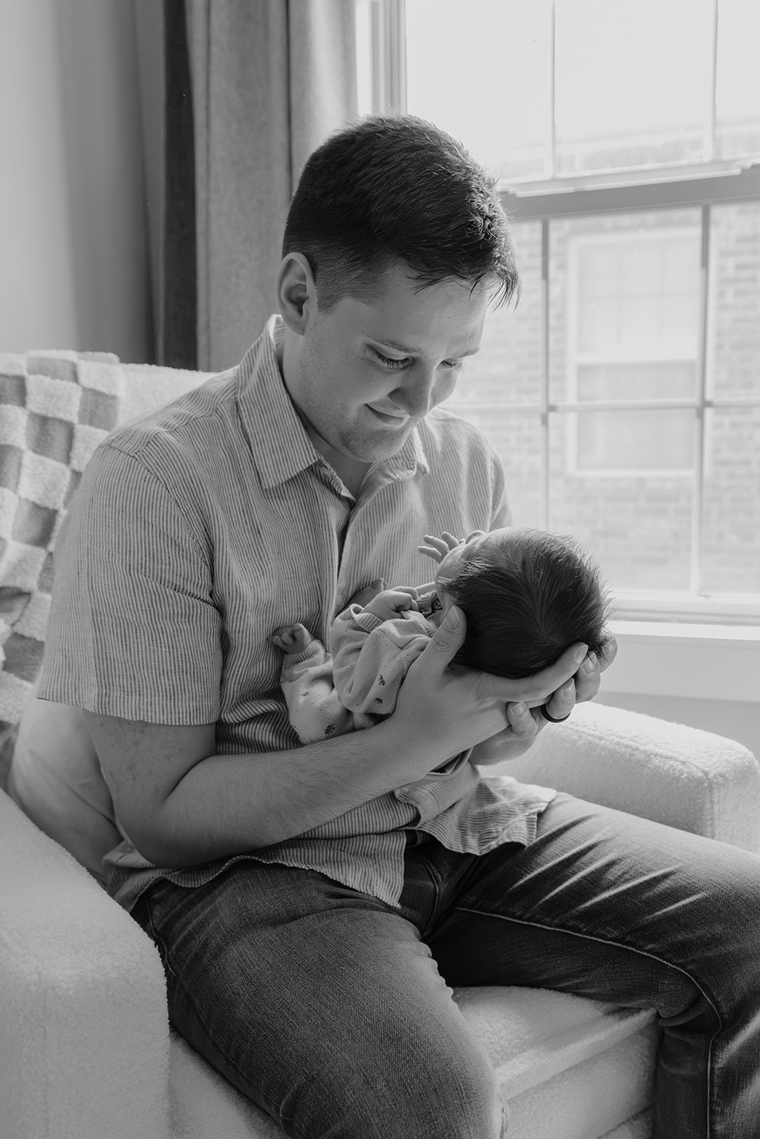 Father and newborn son in nursery during in-home newborn photoshoot