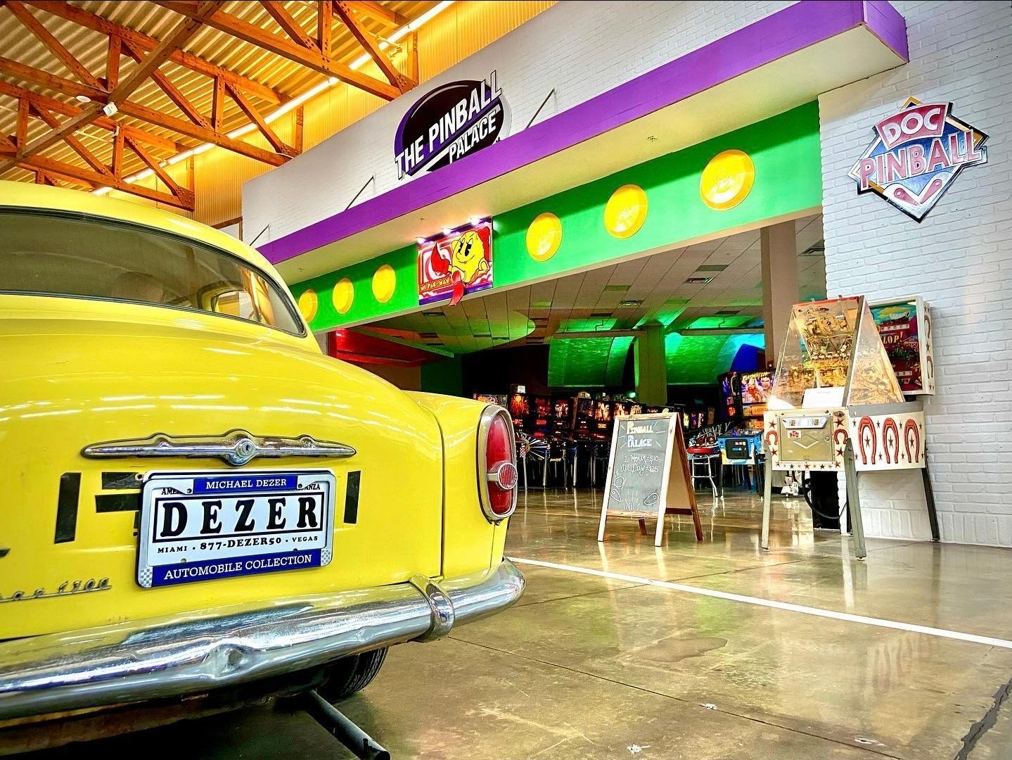 Retro yellow car parked in front of a colorful retro-style diner entrance.