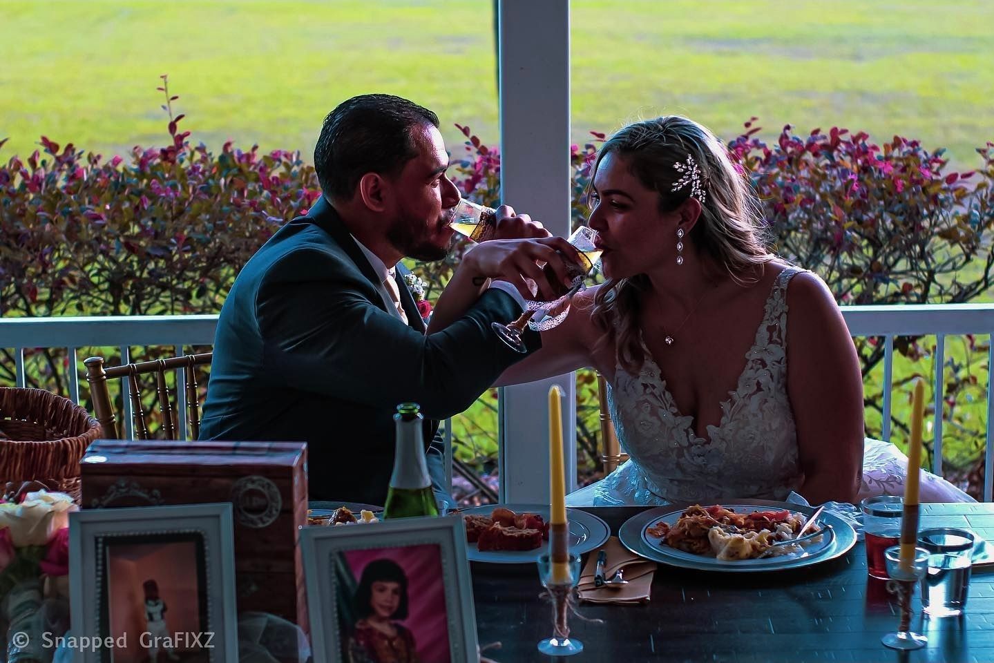 Couple sharing food at an outdoor dining table during golden hour.