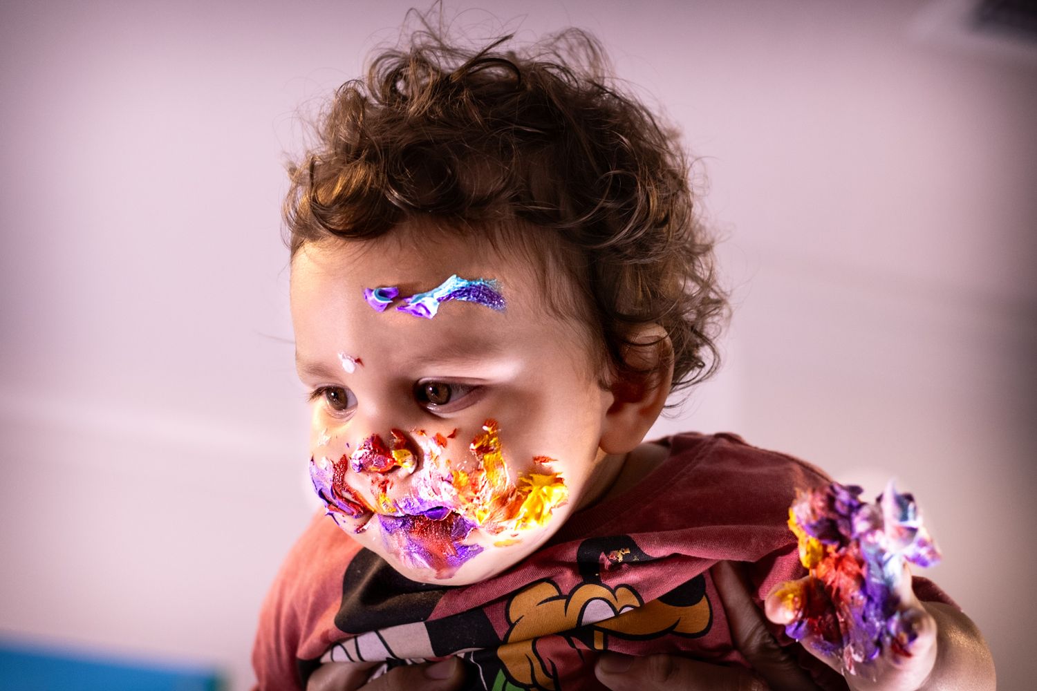 Close-up shot of a child with cake frosting on their face during a birthday celebration.