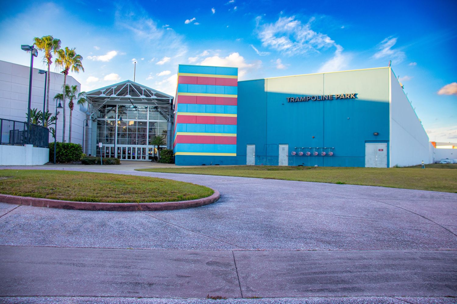 Industrial warehouse buildings with blue and red stripes against a bright blue sky.