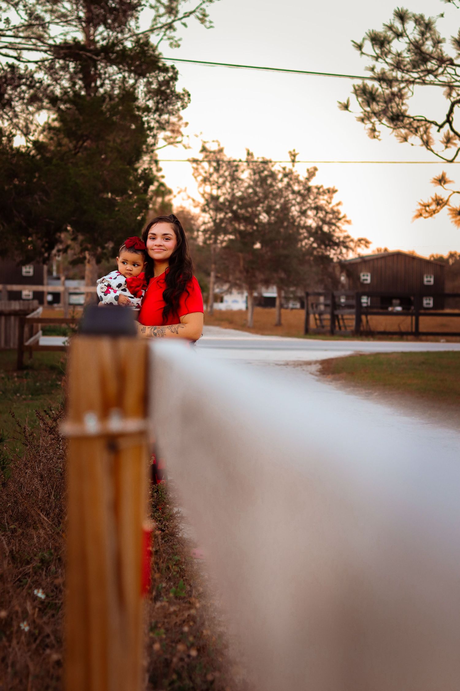 Artistic landscape photo with blurred fence and figures in red visible in background.