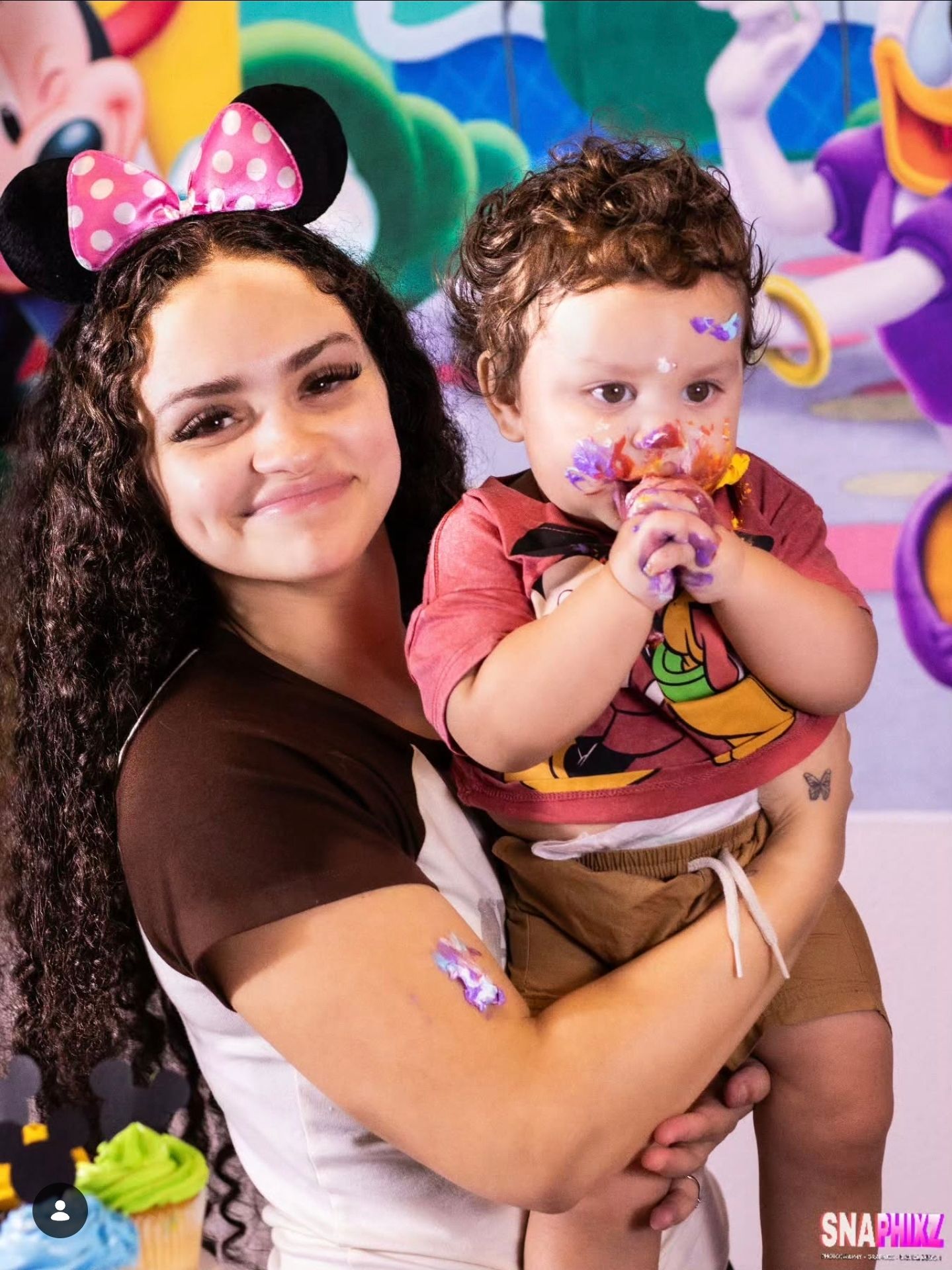 Child enjoying birthday celebration with Disney-themed decorations and balloons.