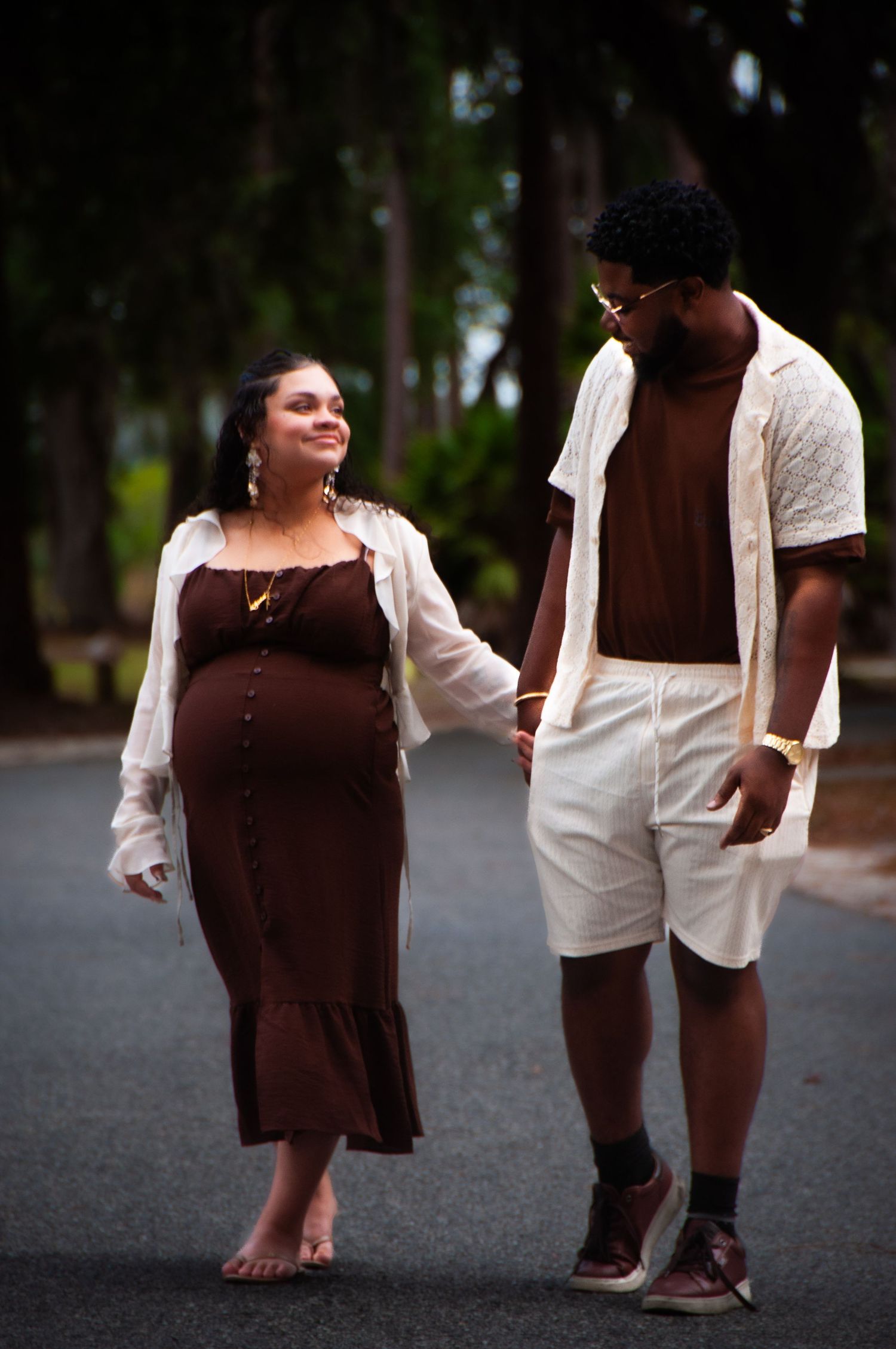People walking together outdoors at dusk wearing coordinated brown and white outfits.