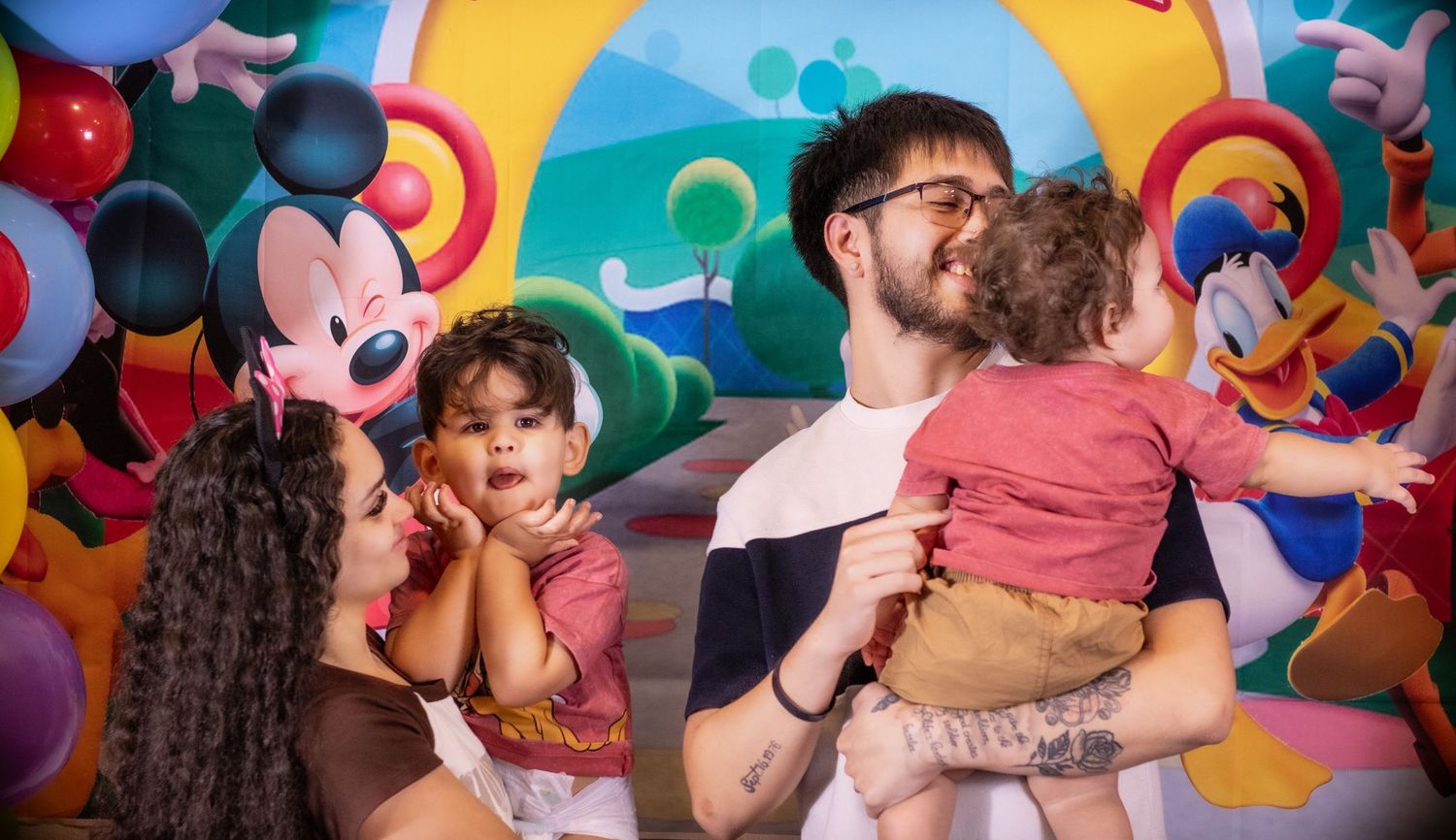 Playful family photos taken at a colorful Disney-themed venue with bright backgrounds.