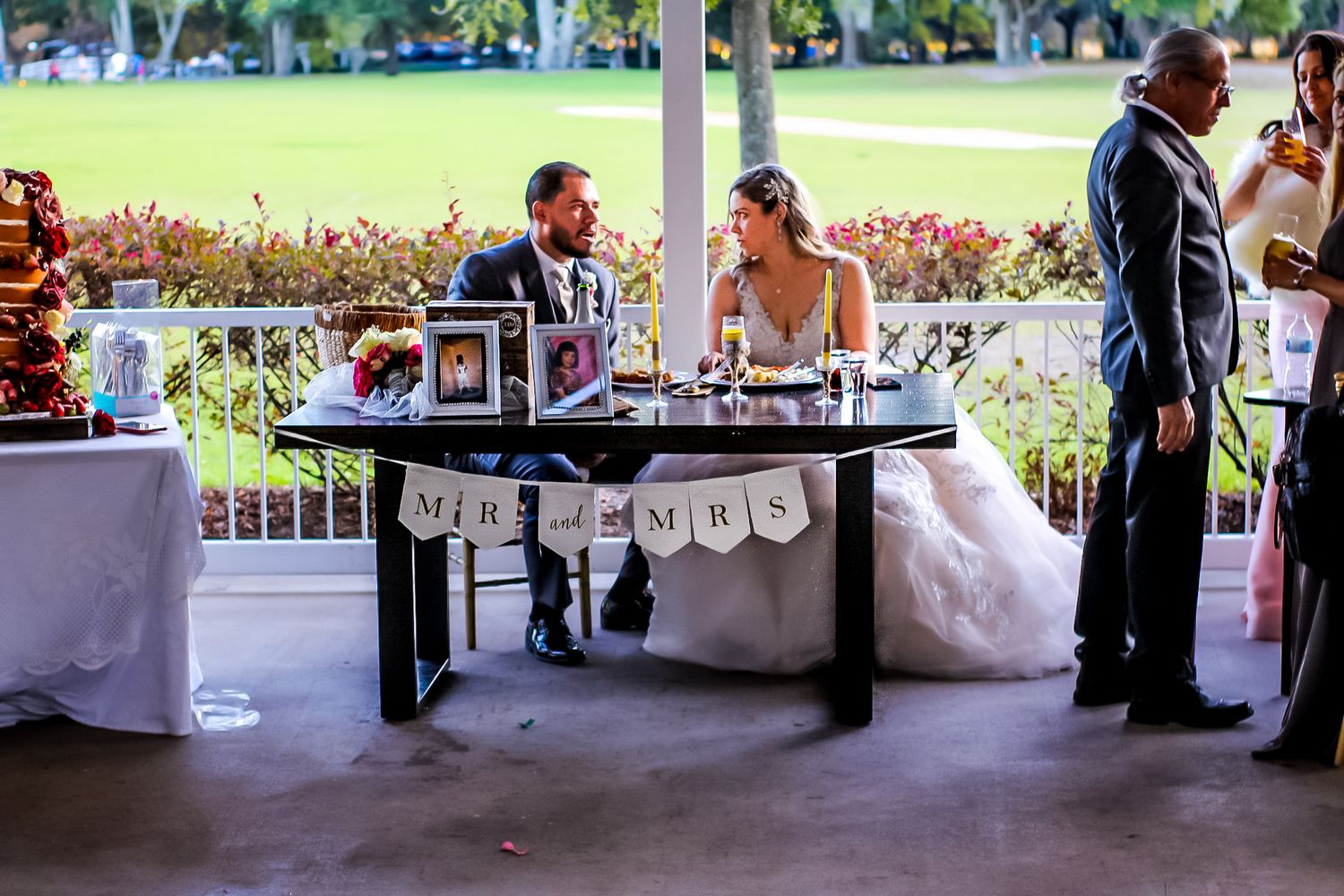 Wedding reception setup with long buffet tables under an outdoor pavilion.