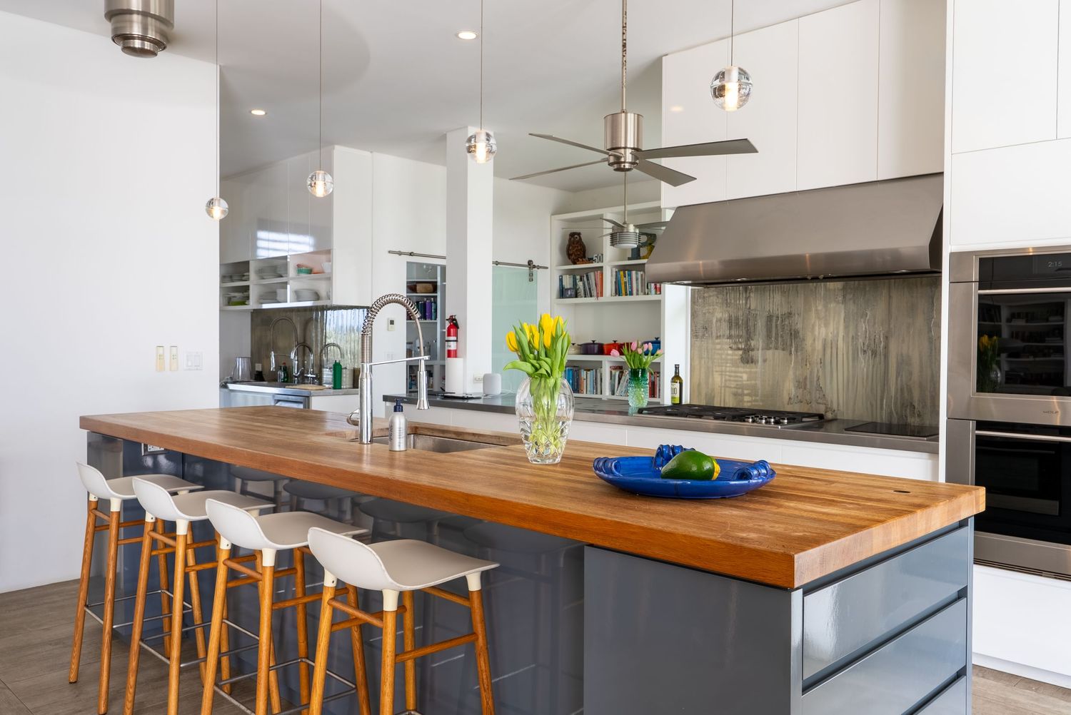 Contemporary kitchen with wooden countertops, modern appliances and bar seating.