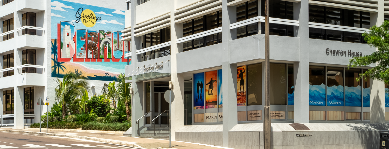 Panoramic view of a modern white commercial building with artistic murals.