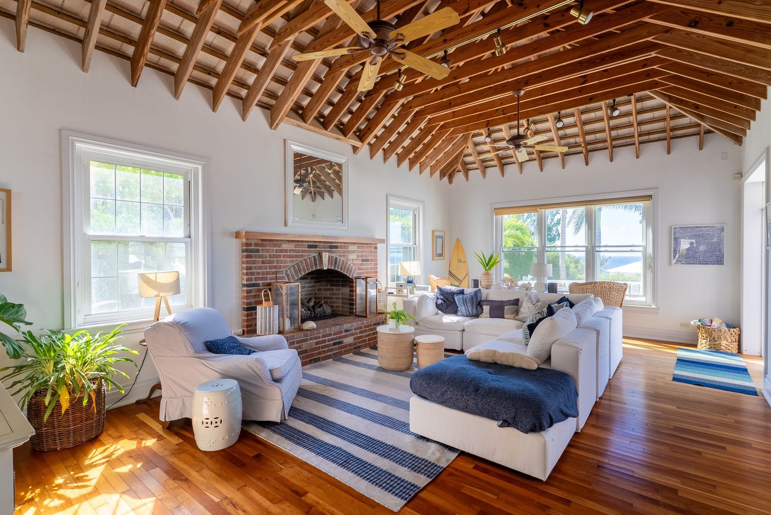 Open concept living space with vaulted wooden ceiling and coastal decor.