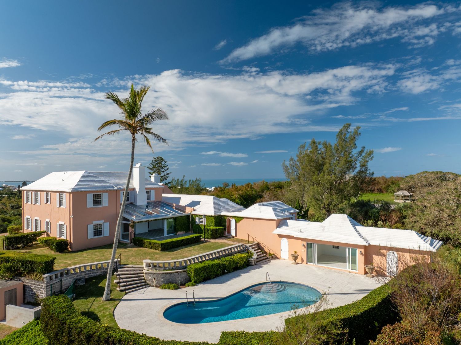 Aerial panorama of beachfront properties with swimming pools and tropical landscaping. Drone photogrpahy.