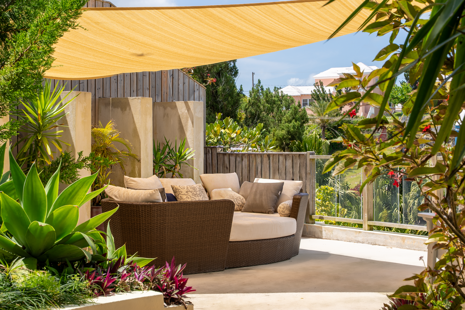 Tropical patio area with comfortable outdoor seating and lush garden landscaping.