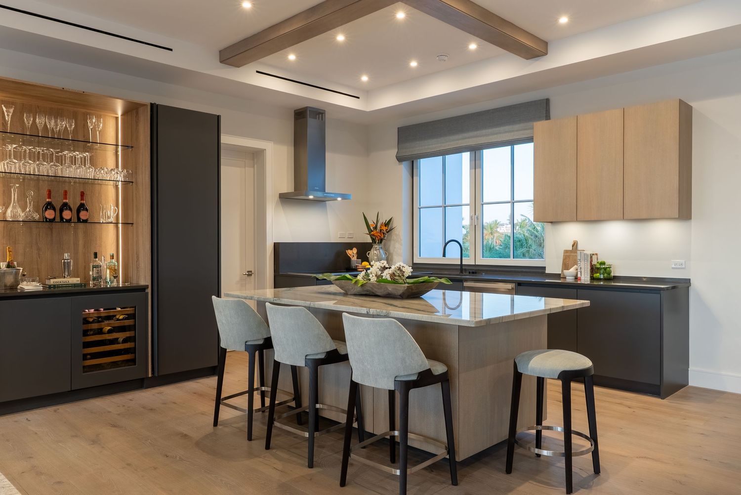 Modern kitchen with sleek dark cabinetry, pendant lighting, and comfortable bar seating.