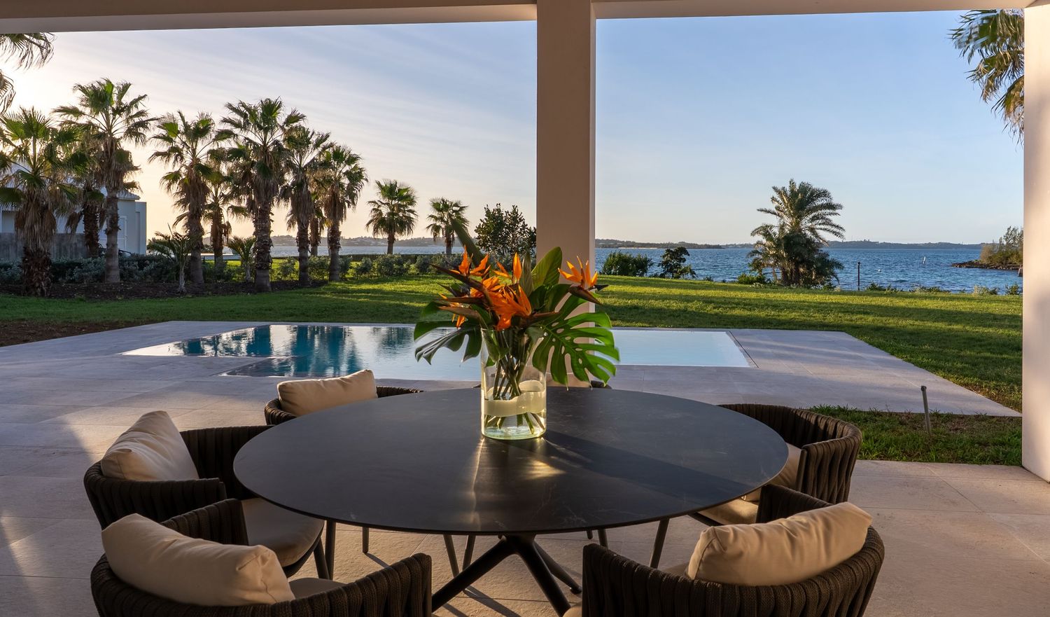 Oceanfront patio with covered seating area and panoramic views of palm trees and coastline.