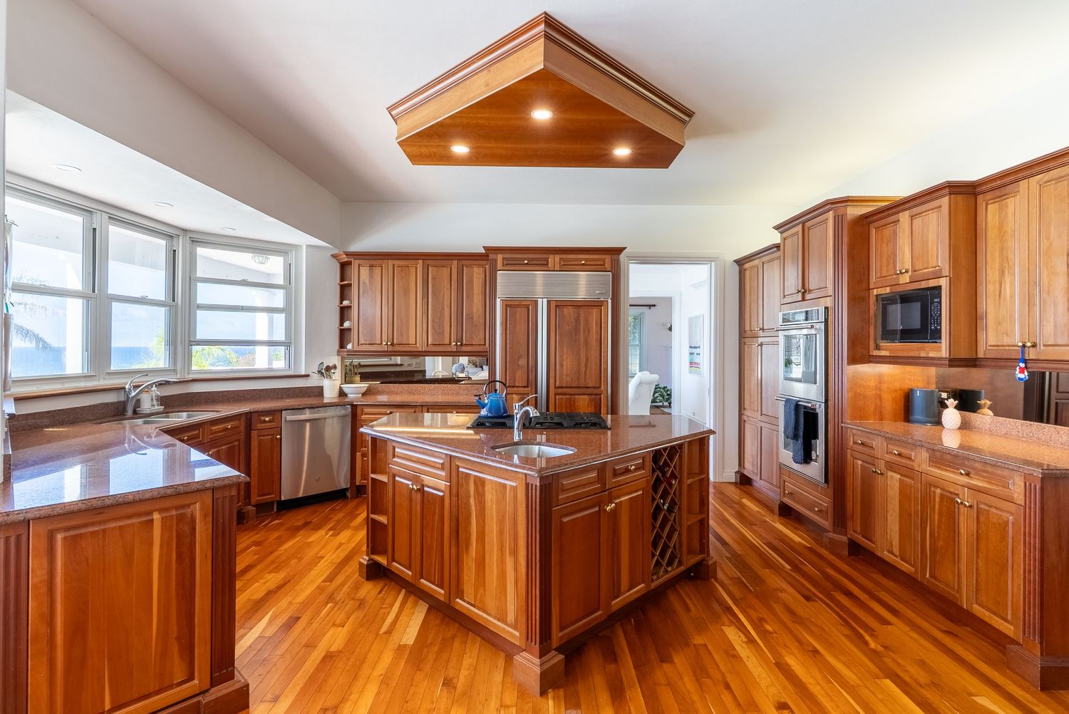 Luxury kitchen with rich wood cabinetry and modern stainless steel appliances.