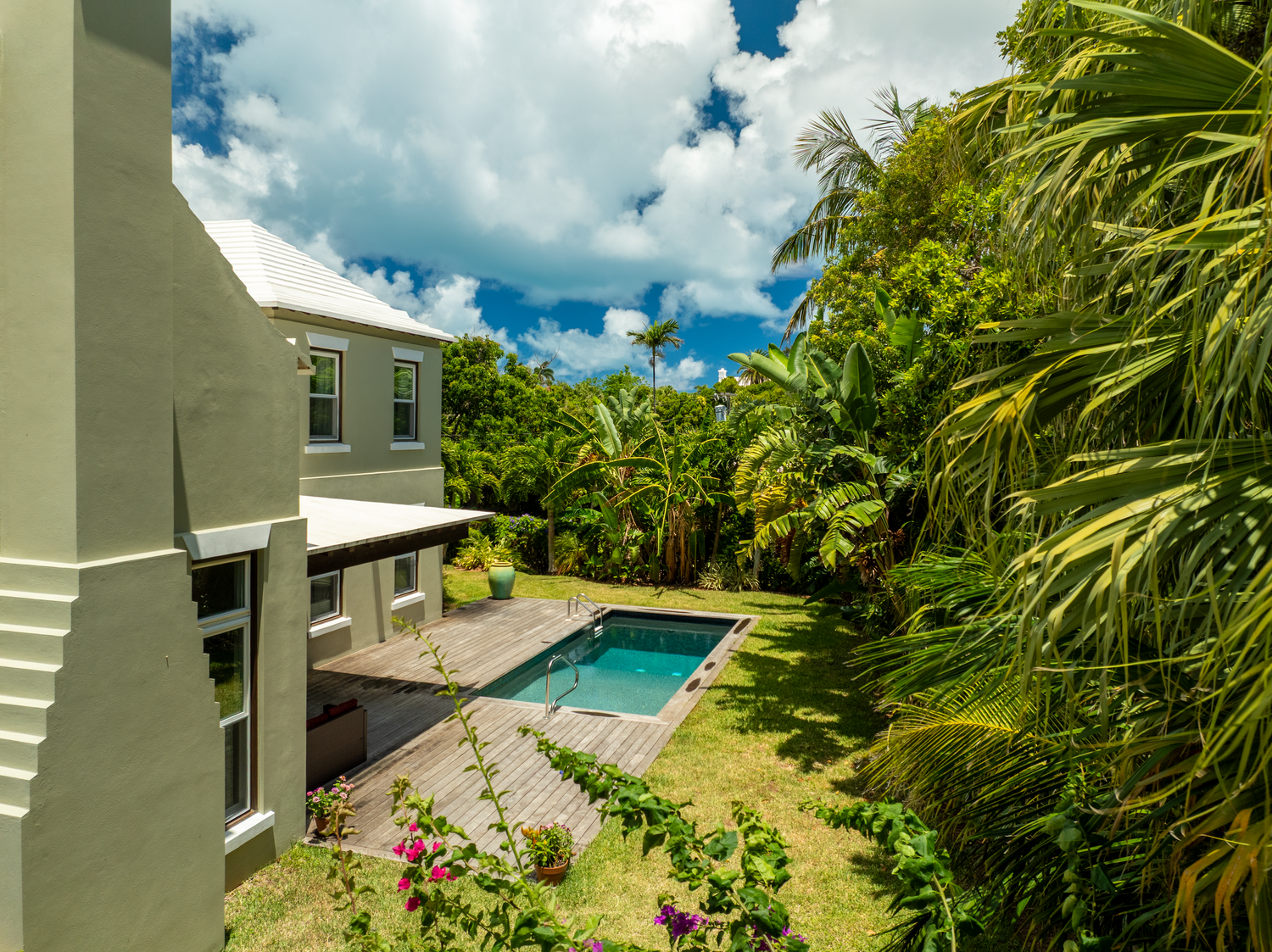 Resort style property view showing swimming pool and tropical landscaping from elevated perspective. Drone photogrpahy.