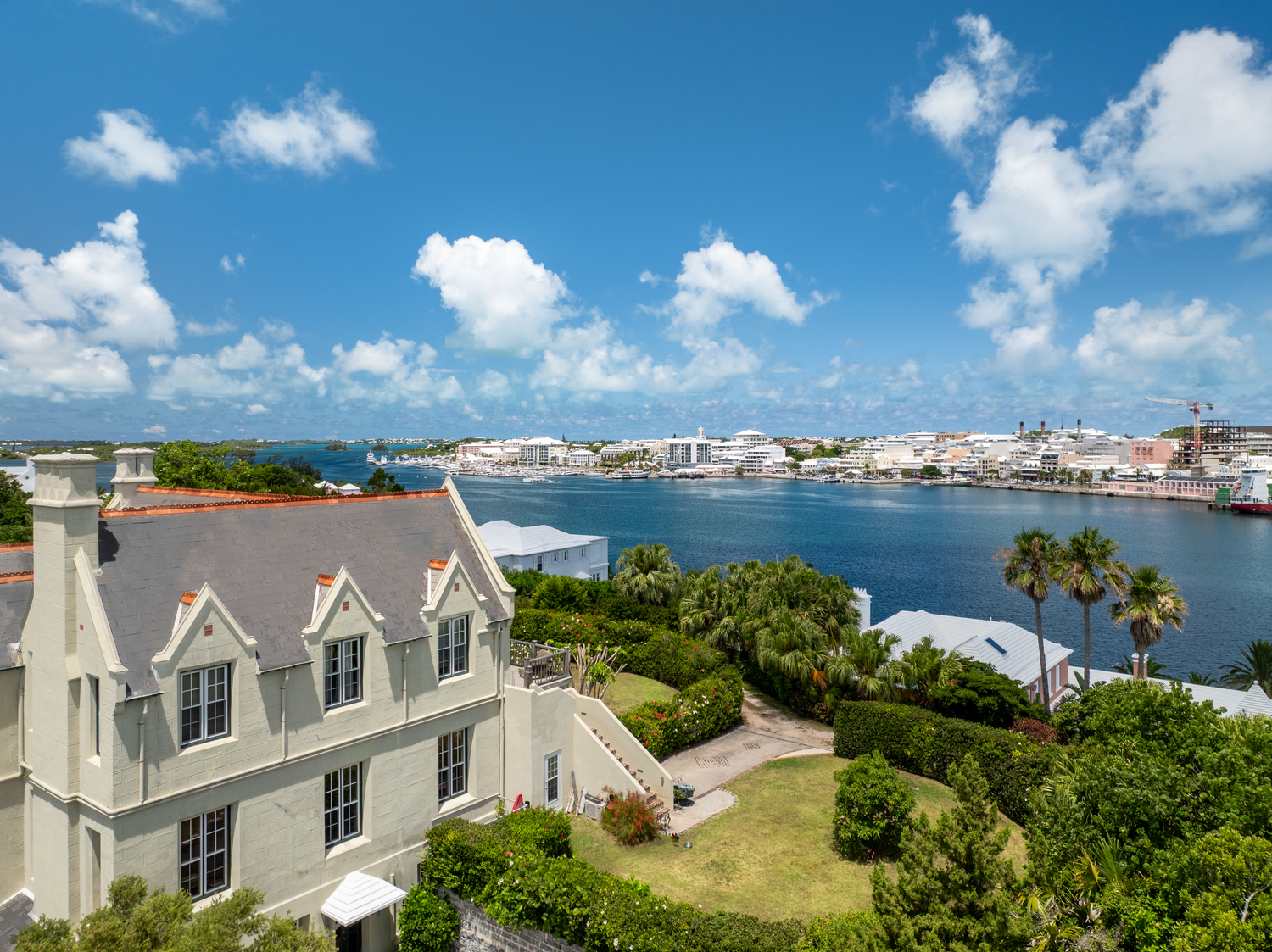 Sweeping coastal views of luxury homes and harbors under bright blue skies. Drone photogrpahy.