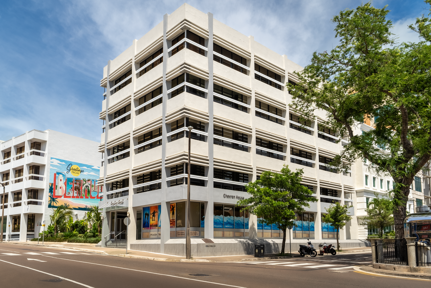 White commercial building complex with colourful murals on display.