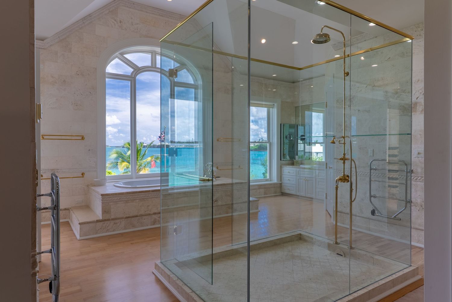 Modern glass-enclosed bathroom with ocean views and contemporary fixtures in a luxury residence.