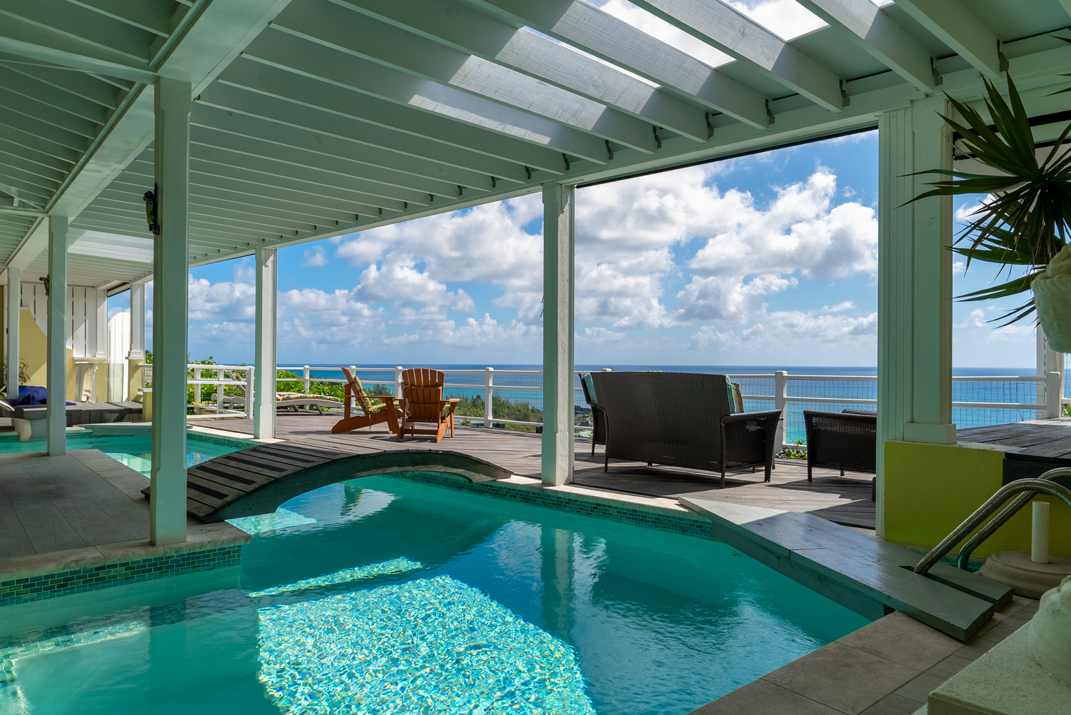 Luxurious indoor pool with ocean views through floor-to-ceiling windows.
