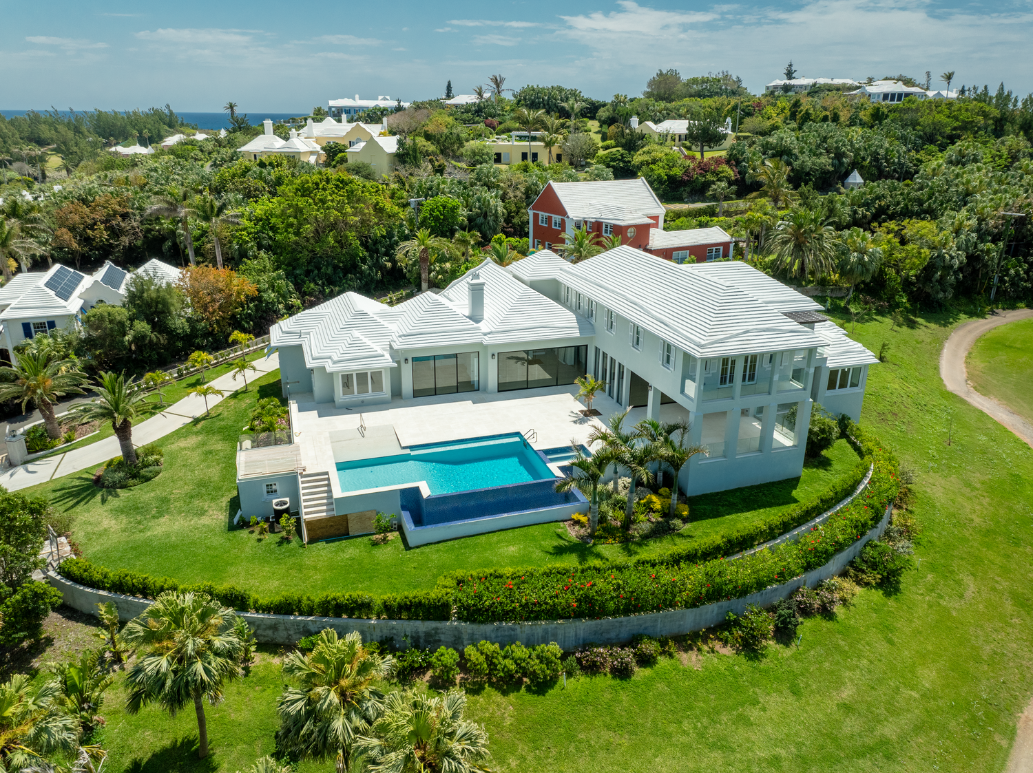 Aerial view of luxury waterfront homes with pools and lush landscaping in an upscale neighborhood. Drone photogrpahy.