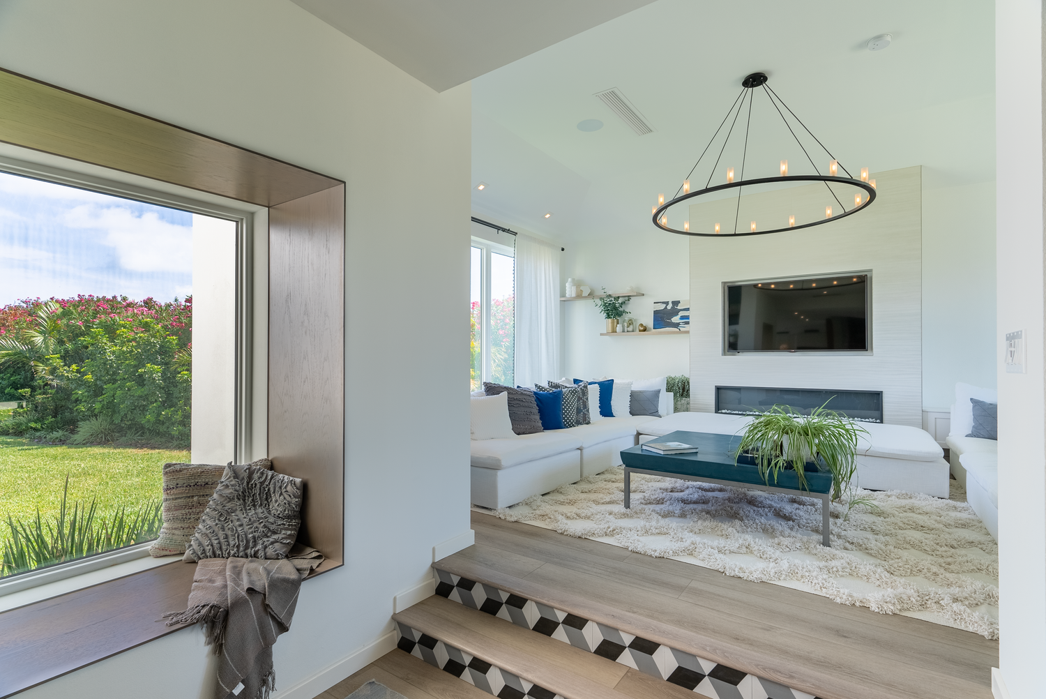 Contemporary open-concept living space with panoramic windows overlooking water views.
