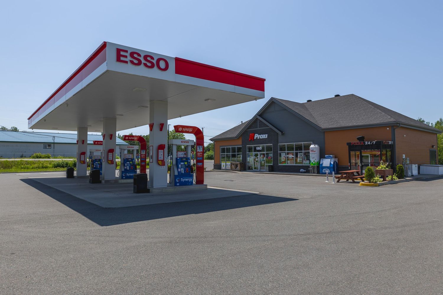Panoramic view of multiple Esso gas station locations showing red and white branded fuel stations and convenience stores.