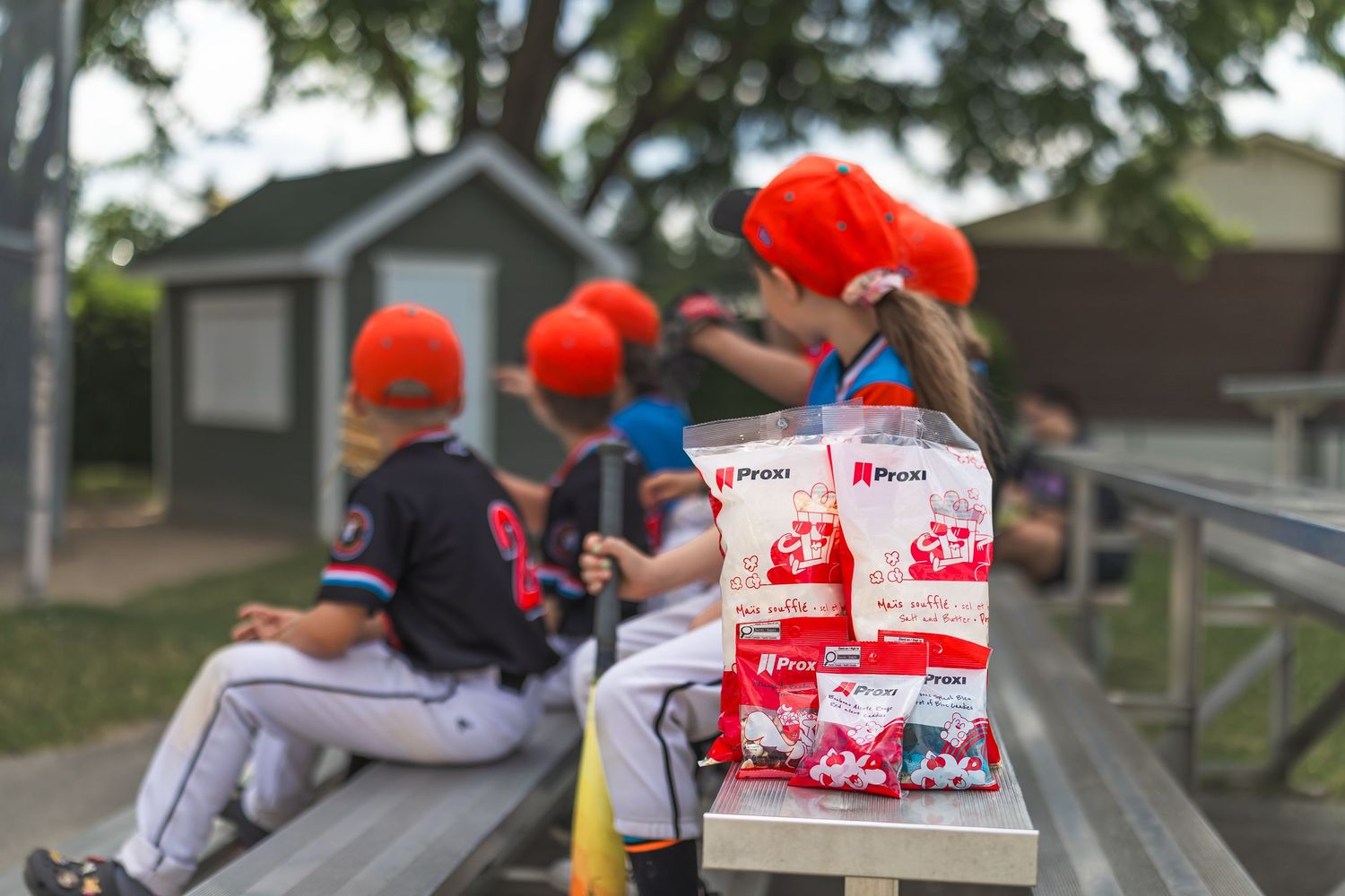 Group of people wearing orange hats and gray shirts working together to pack boxes with supplies for community service.