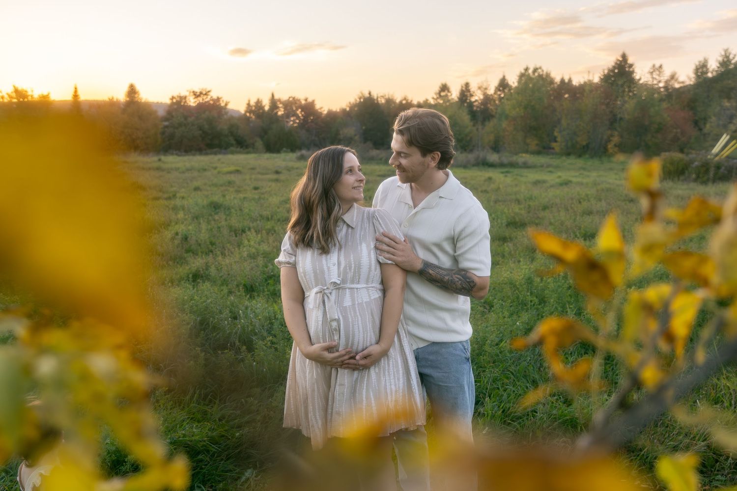 Family walks through wildflower field during golden hour sunset photography session.