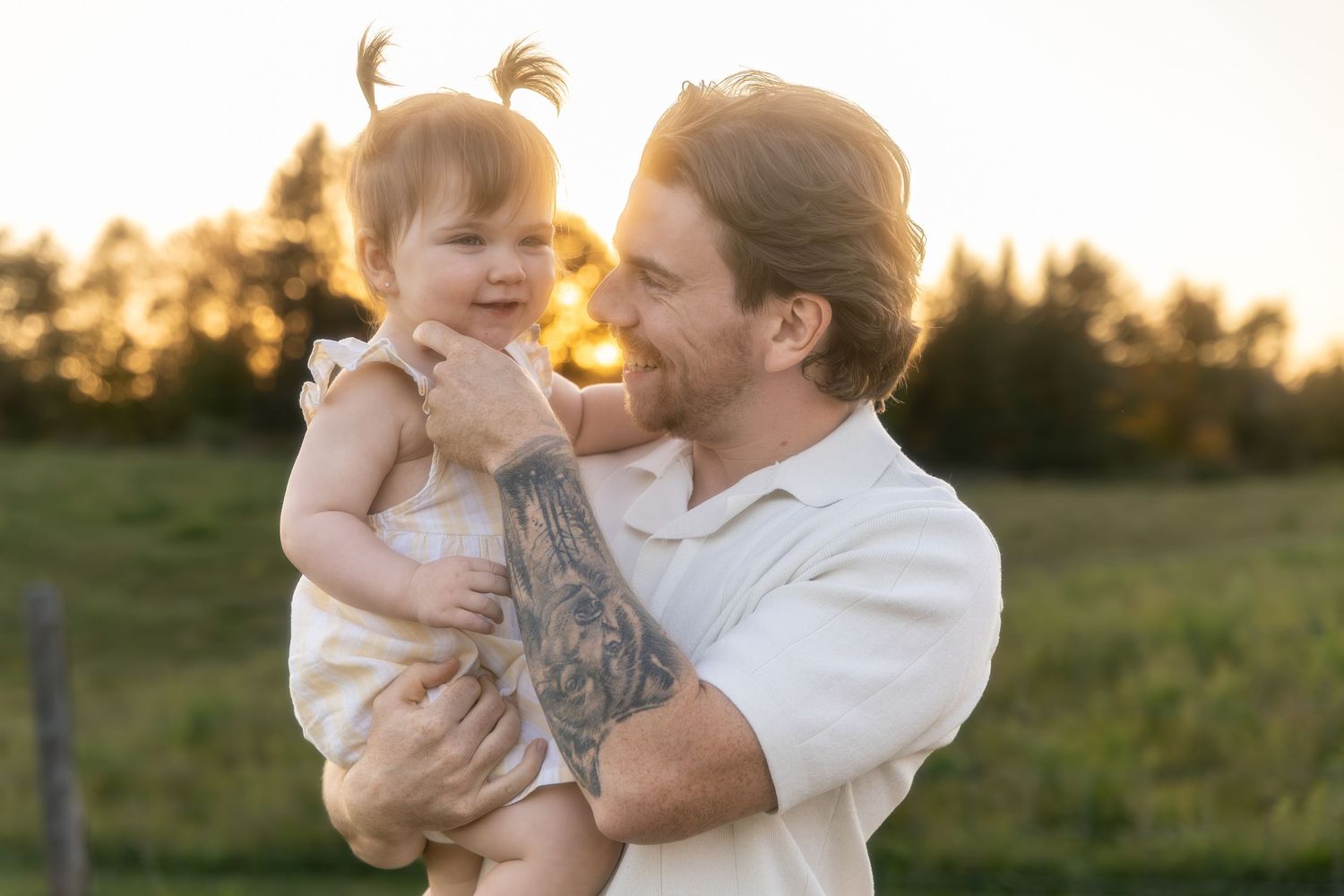 Family shares intimate moments and laughter together during outdoor sunset photoshoot.