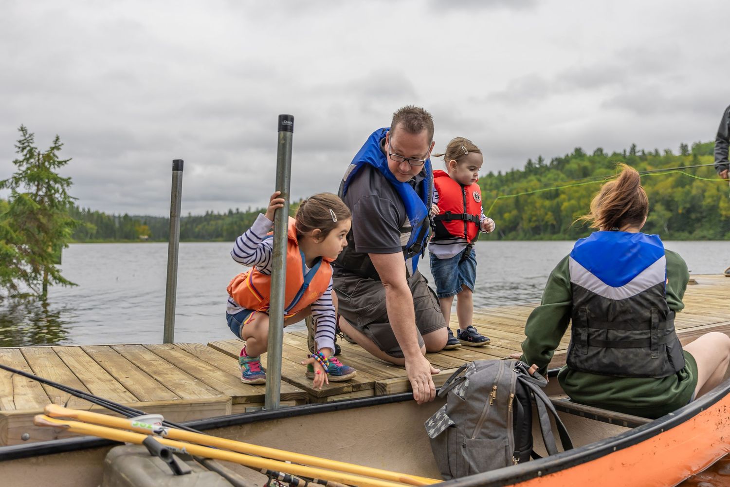Group enjoying outdoor activities on wooden docks by a serene lake.